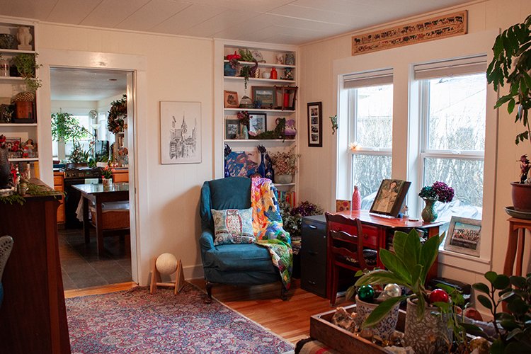 The sitting room includes built-in bookshelves, large windows for plenty of natural light and historic craftsman style trim around the doors.