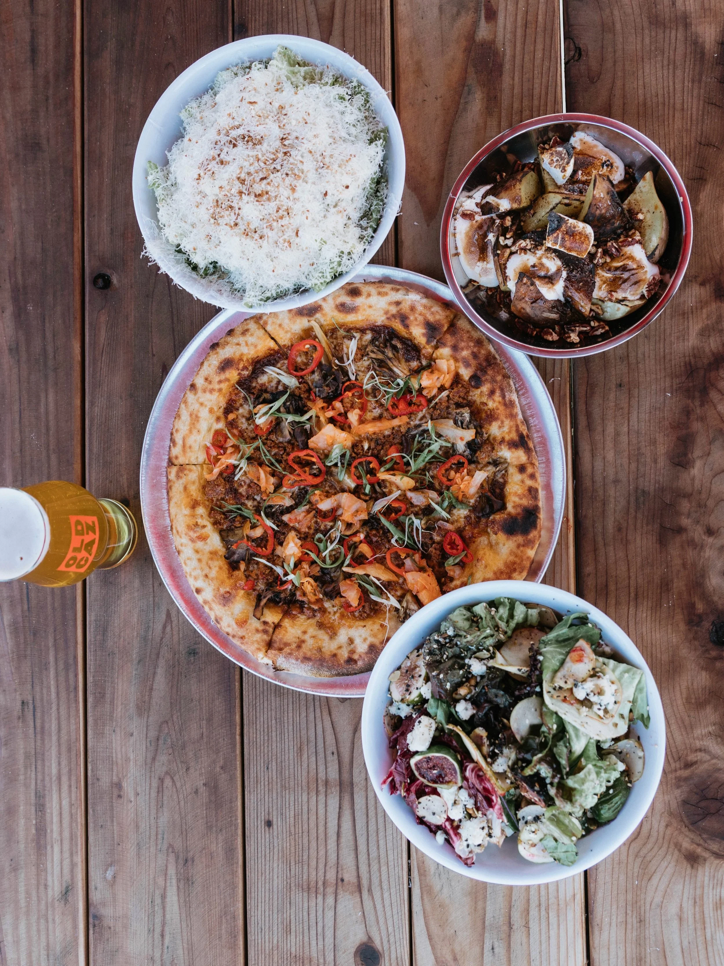 The pizza hits the table, the CAZ Eats crew adds one more snowfall of cheese, and someone grabs an extra chair.

Cold beer, a few friends, and Wednesday dinner at the Backyard. This season isn&rsquo;t over yet.

Doors open at 3 PM today.