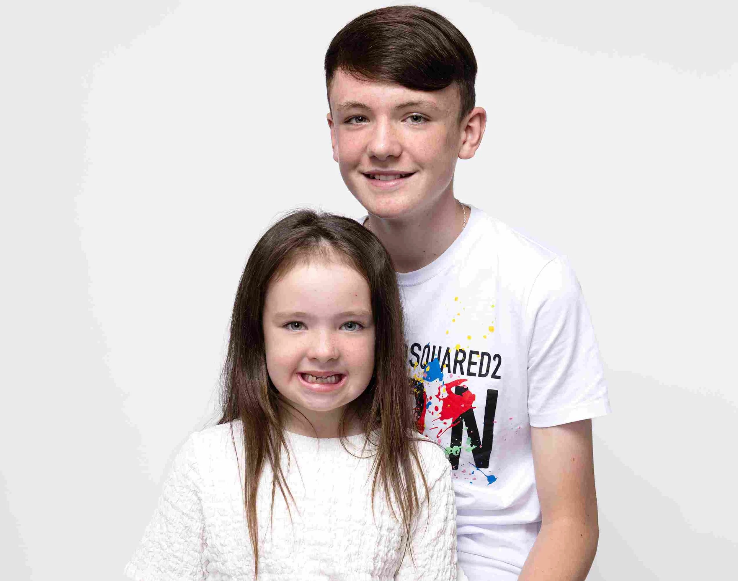 Twin sisters posing in matching blue skirts and white tops during mini photo session in Dublin