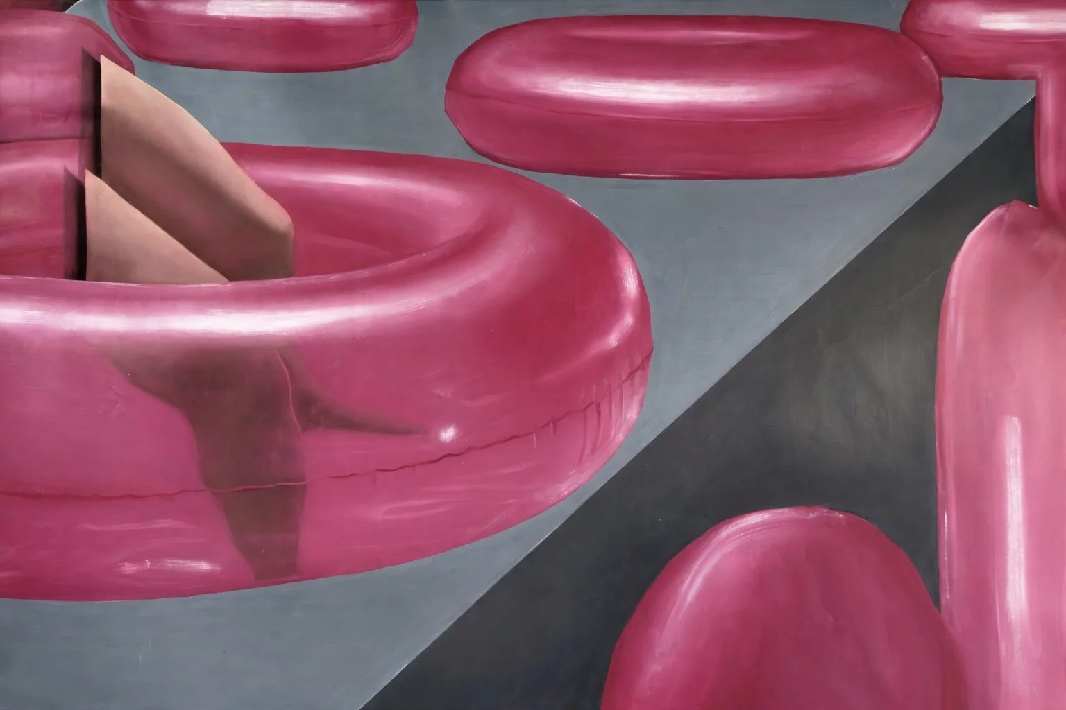 Close-up of pink abstract shapes that resemble doughnuts on a gray surface.