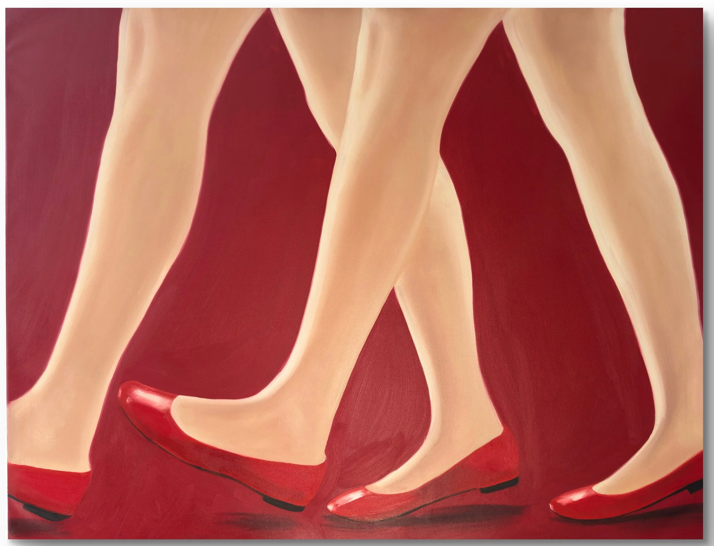 Close-up of four female legs wearing red high heels walking on a red background.