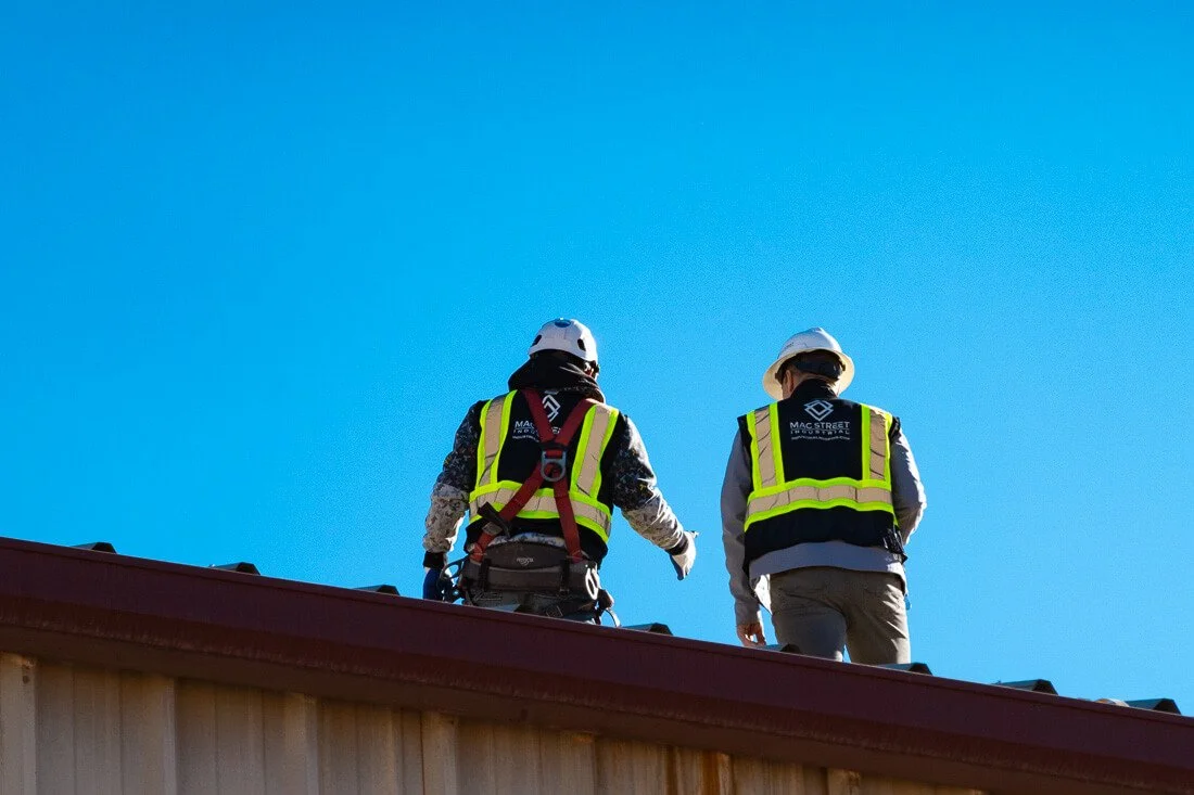MAC Street Industrial workers on rooftop discussing replacement plan