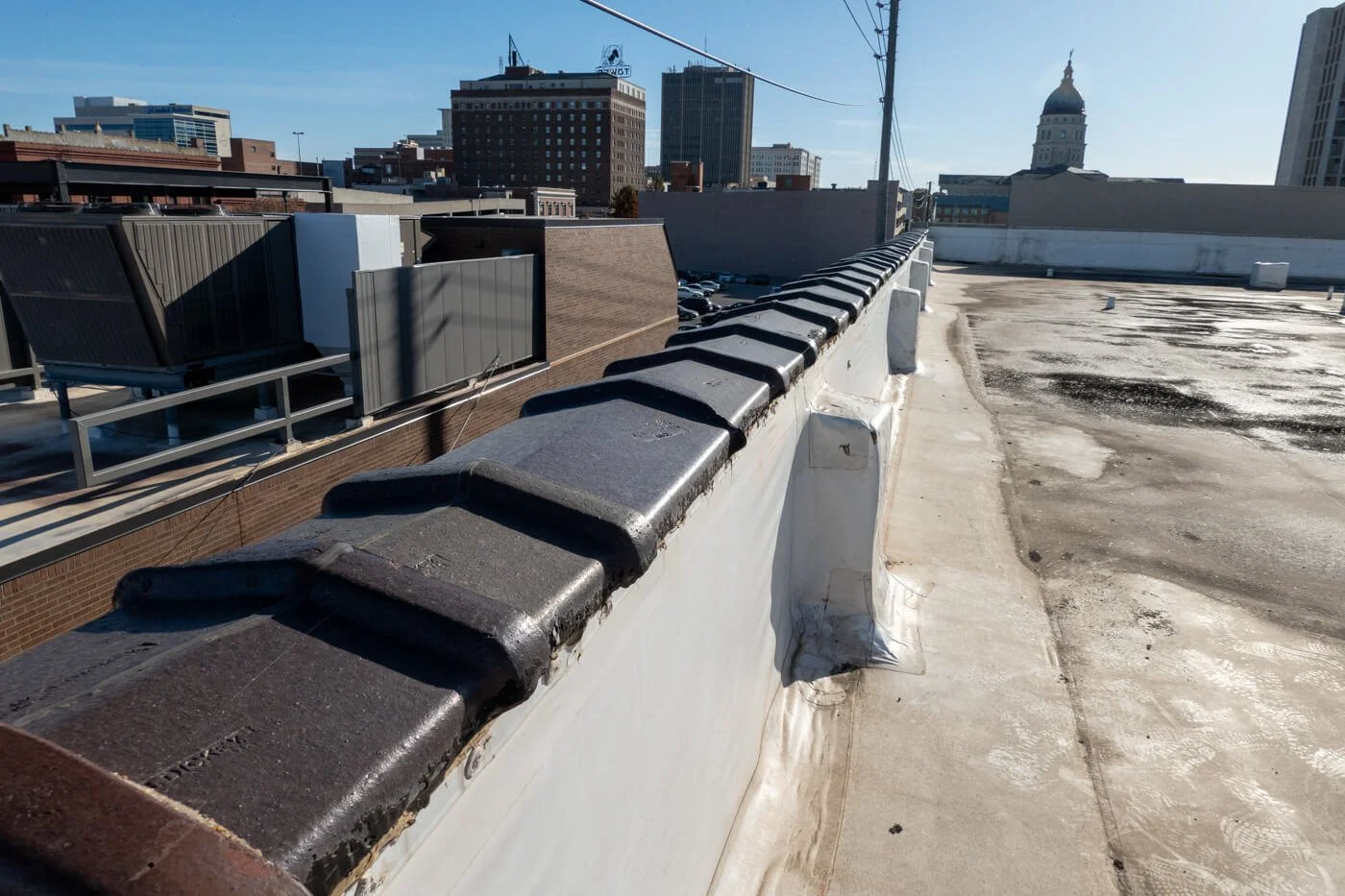 Old tiles on PVC roof parapet needing replacement due to leaking