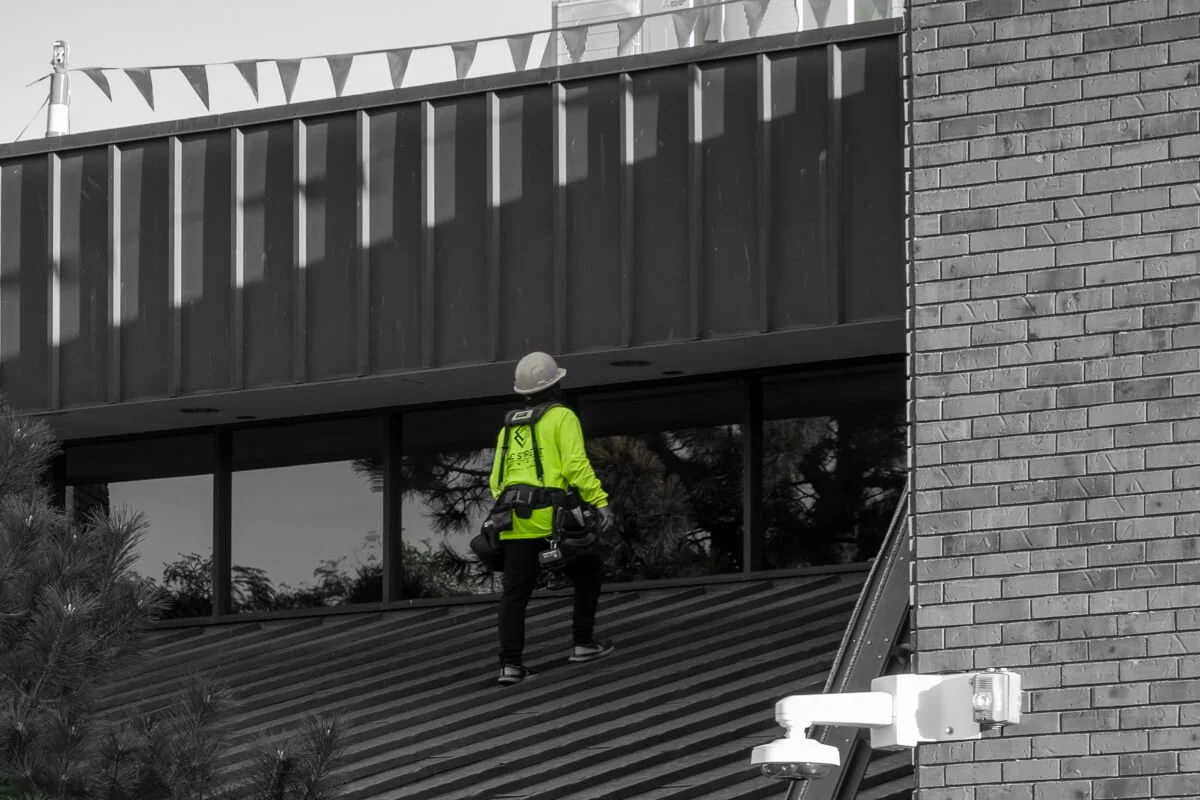 MAC Street roofer inspecting metal on office building bank
