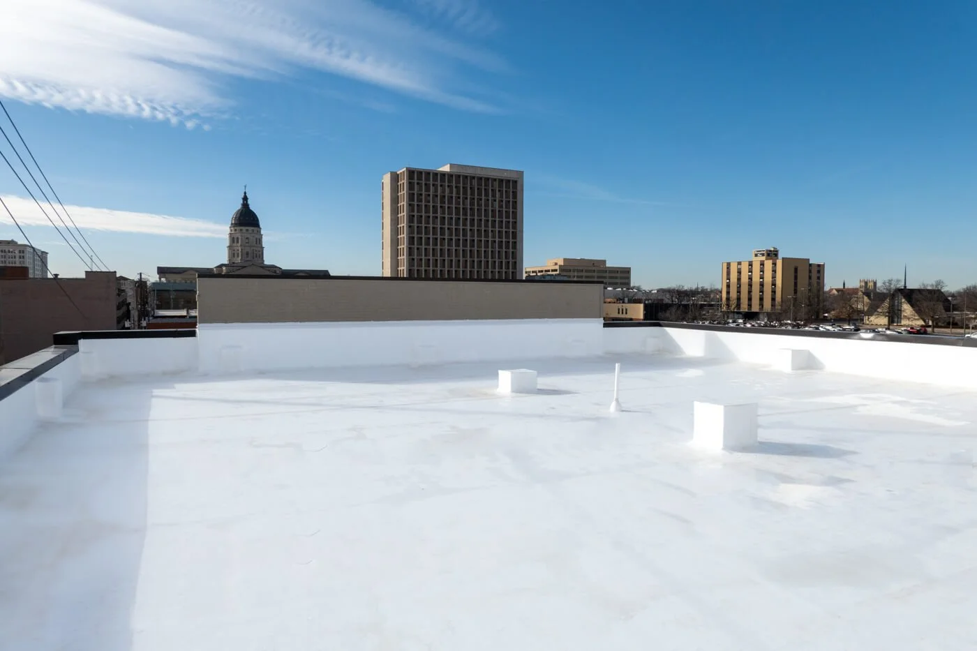 View of new TPO roof system with the Topeka Capitol building in background