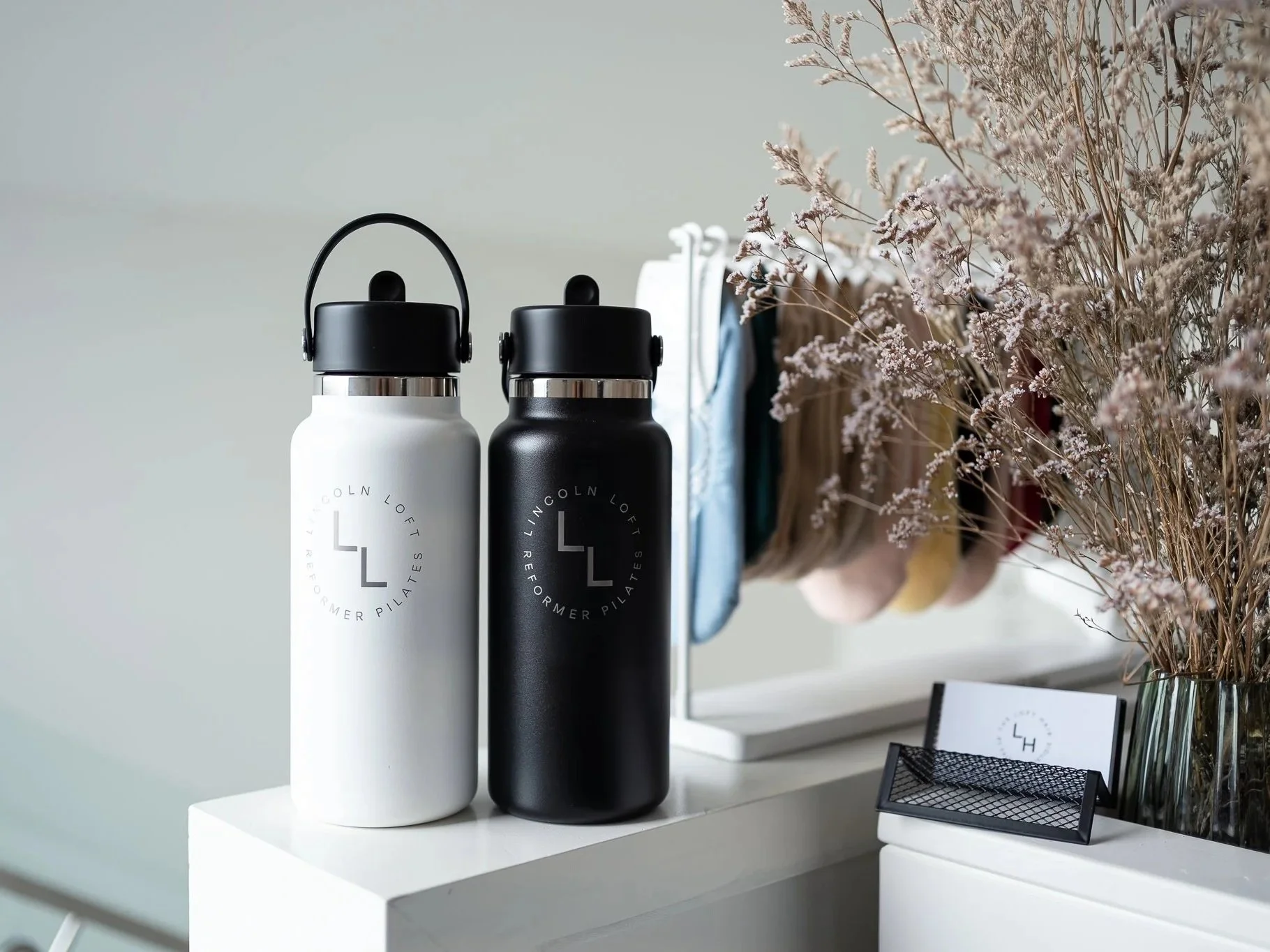 Image showcases some of the Lincoln Loft merchandise, including the Lincoln Loft drink bottles and a range of pilates grip socks.