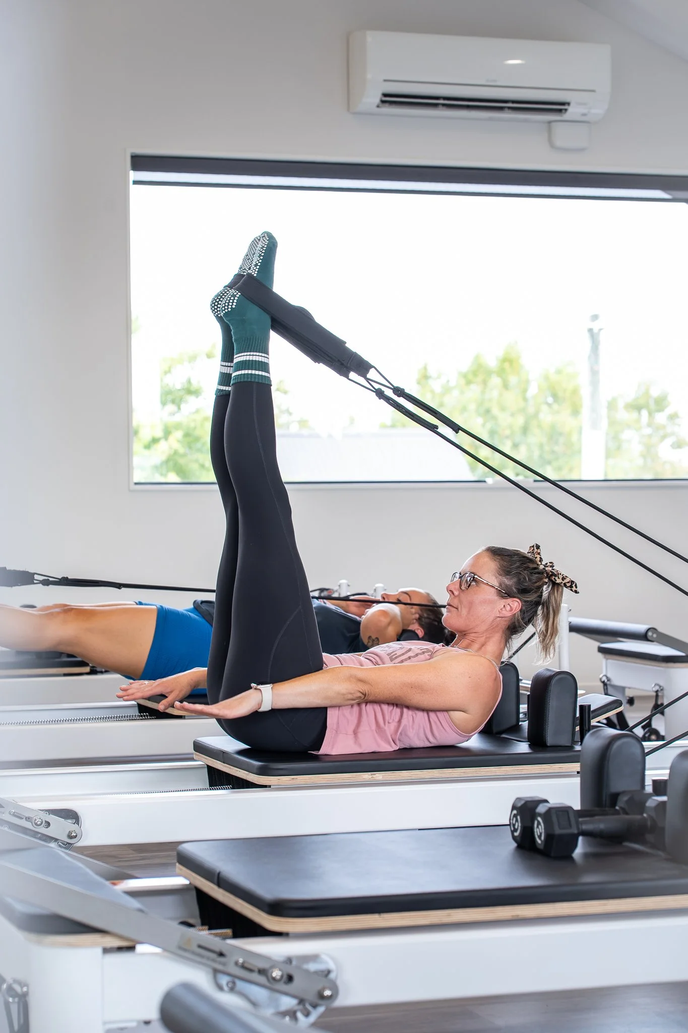 Reformer Pilates Instructor at Lincoln Loft supports a members form at one on one personal training session.