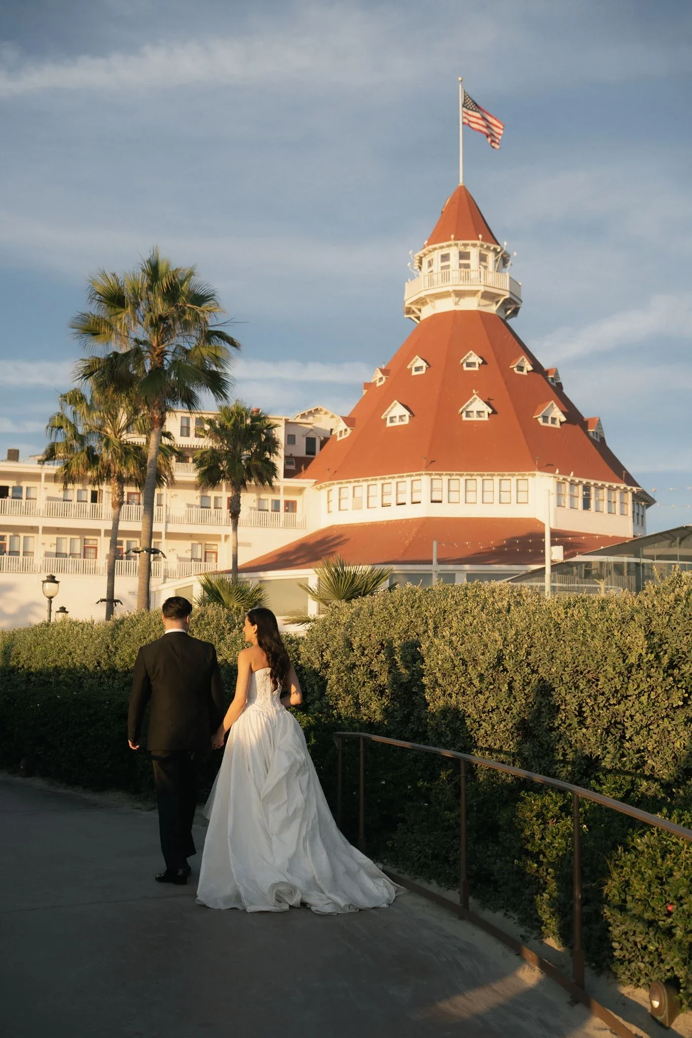 hotel-del-coronado-wedding-couple-walking-by-historic-hotel.webp