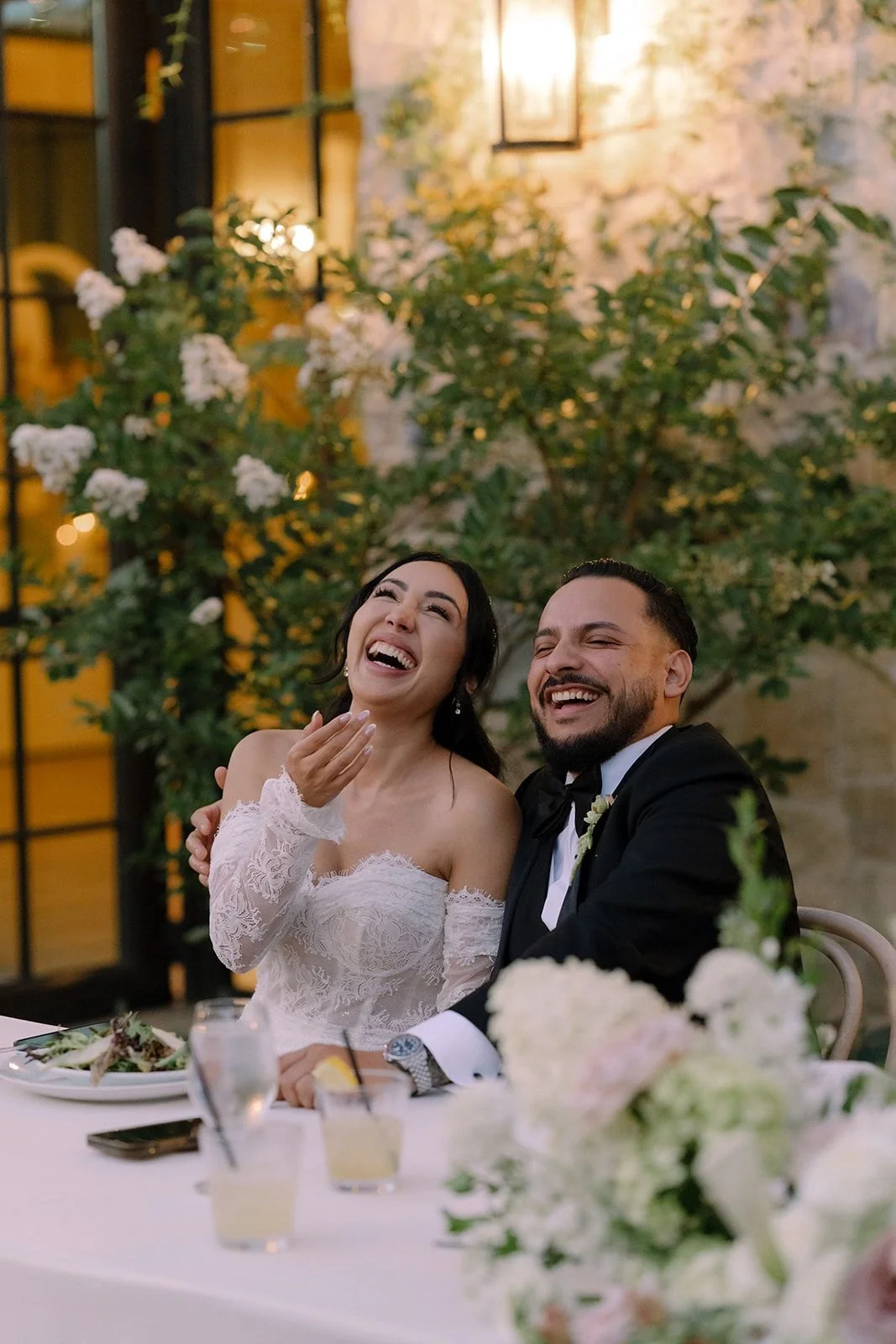 Bride and groom laughing during speeches at their reception