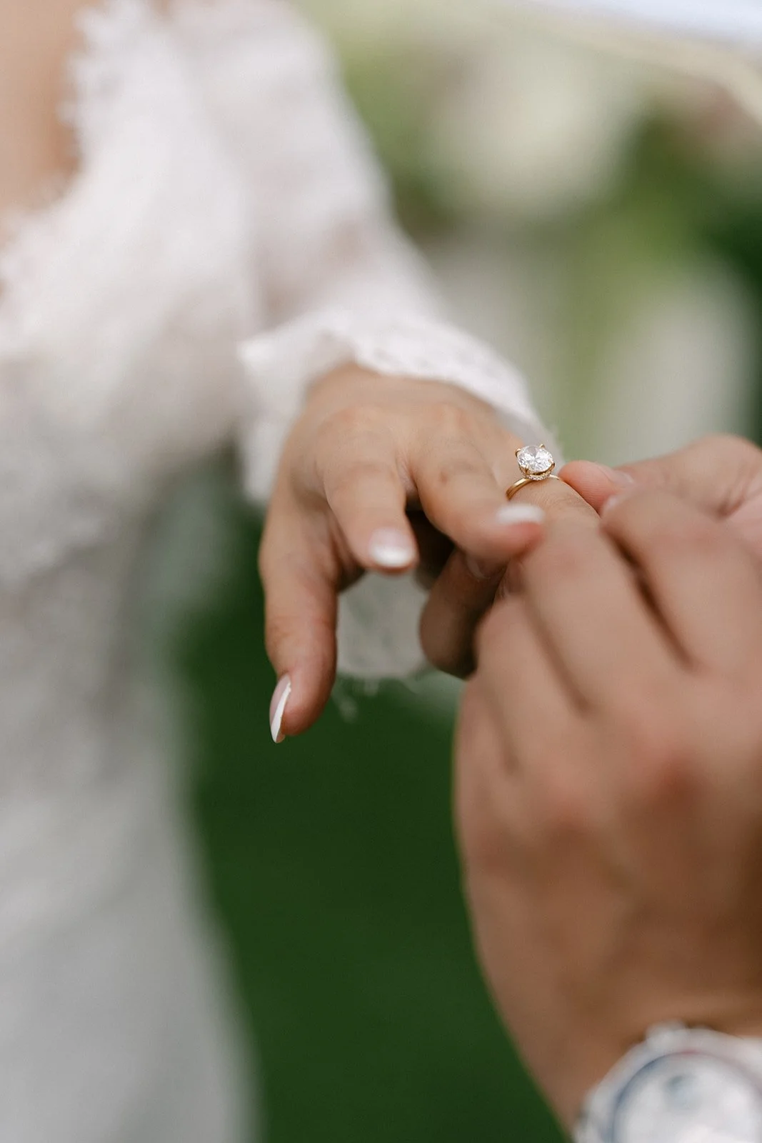Groom putting on bride's ring during ceremony