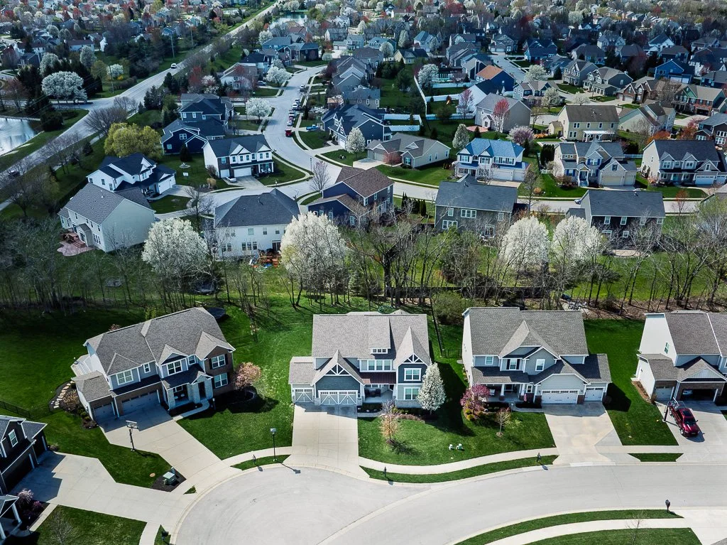 Aerial view of a suburban neighborhood with houses, streets, and trees