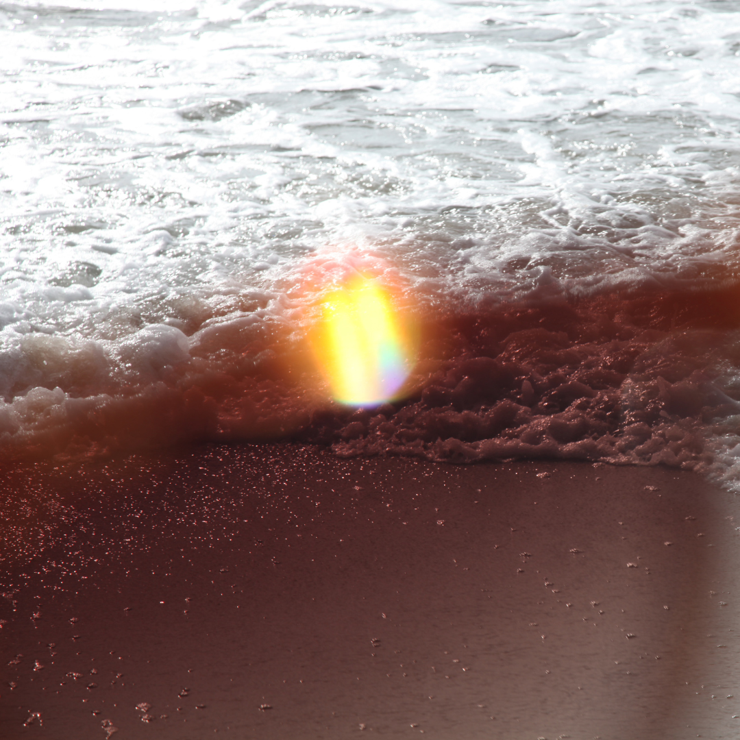 Rainbow fire light as the ocean wave rises on shore