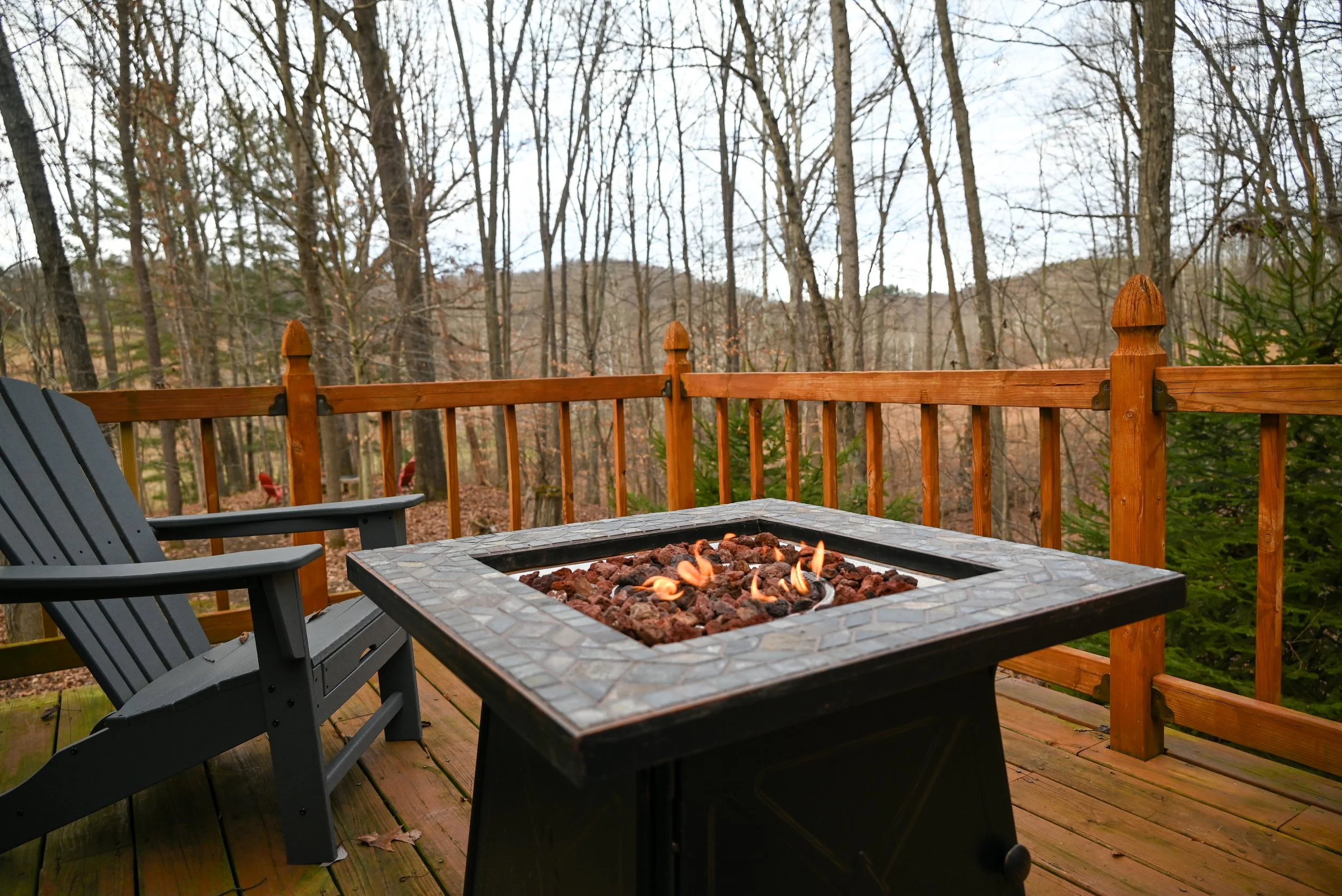 Outdoor fire pit on the deck at Beary Cozy Cabin overlooking the quiet Hocking Hills woods, perfect for a peaceful retreat.