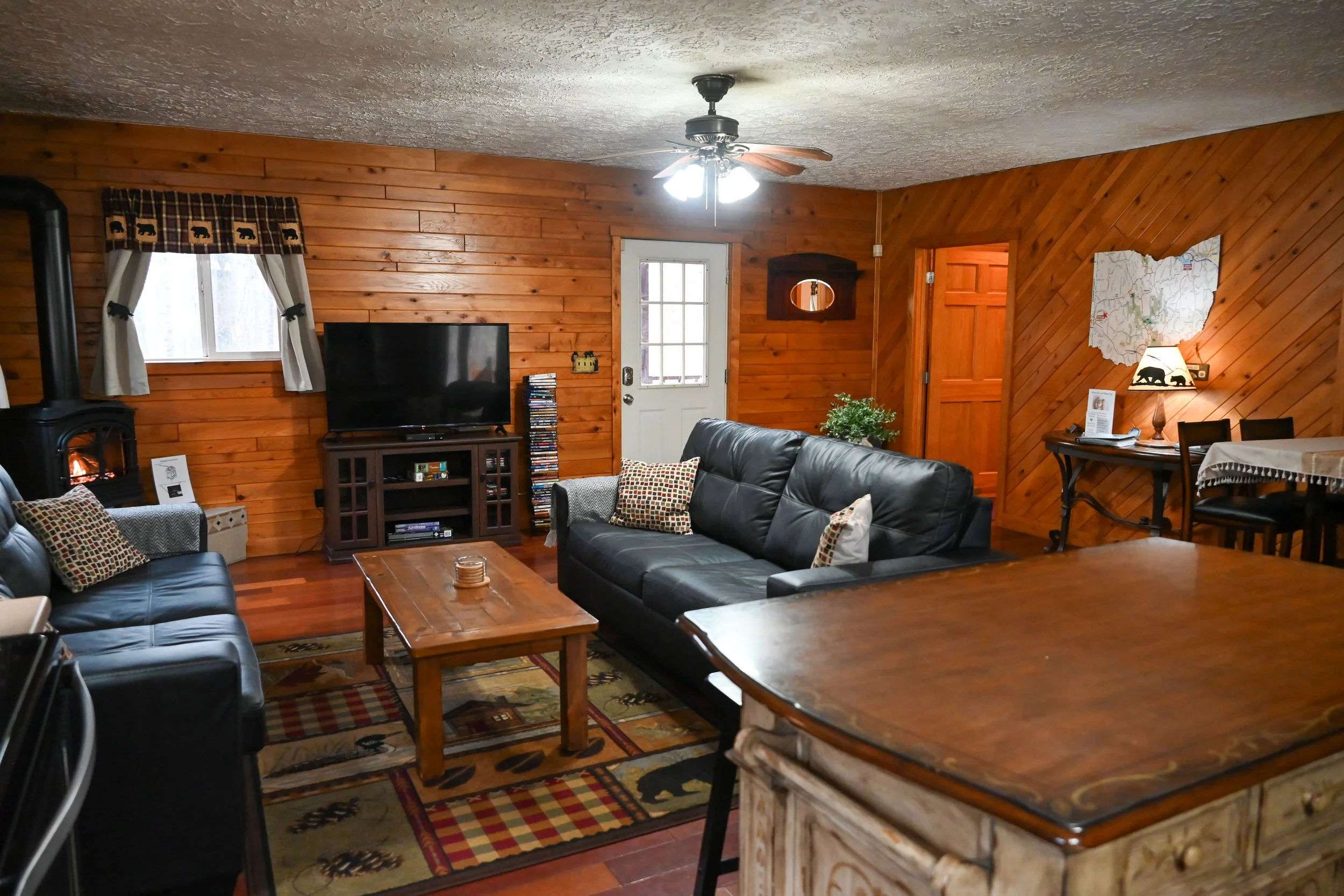 Warm, inviting living room at Beary Cozy Cabin with a glowing fireplace and cozy seating—ideal for romantic evenings in Hocking Hills.