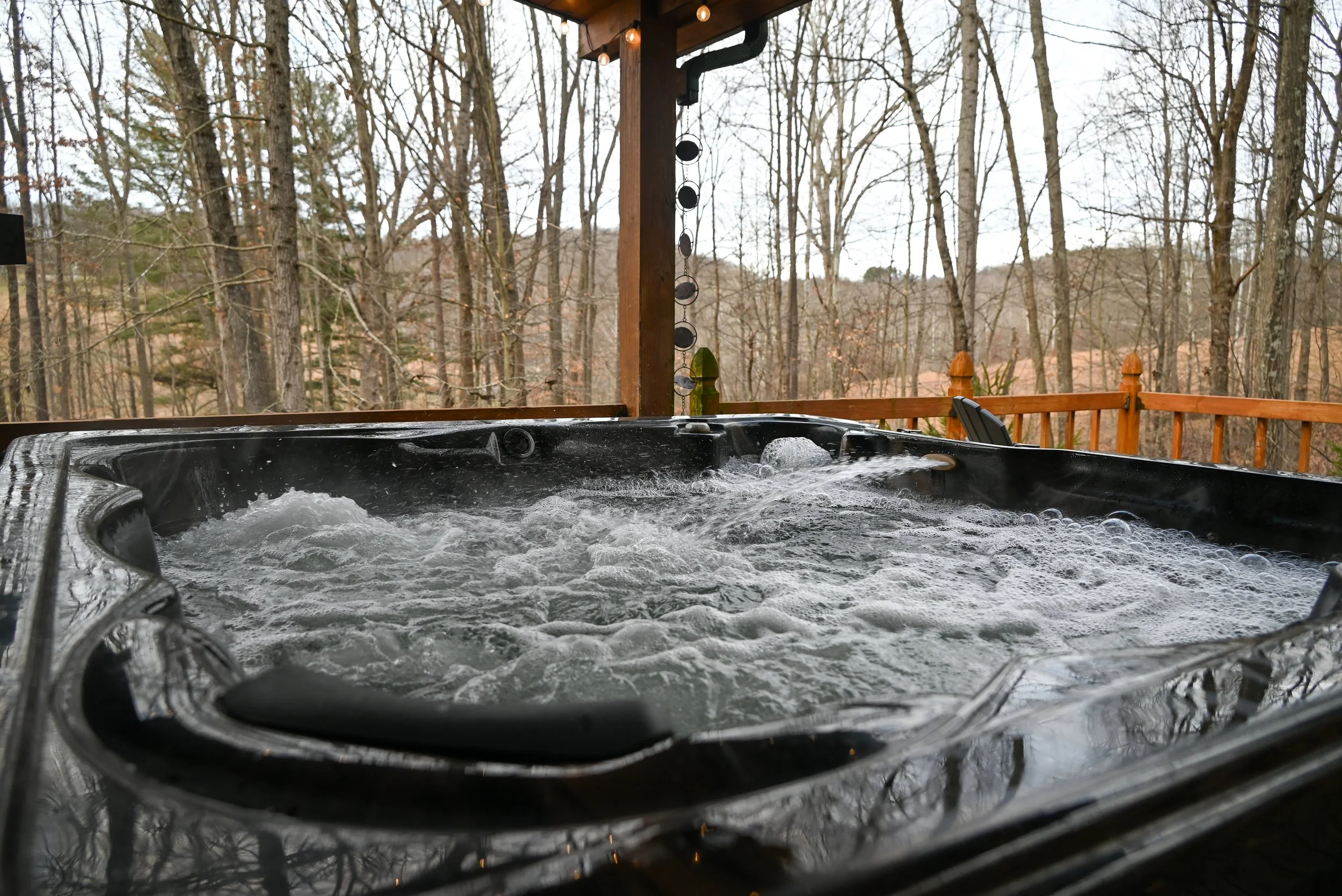 Steaming hot tub at Beary Cozy Cabin overlooking the quiet Hocking Hills forest, perfect for couples seeking a private, romantic escape.