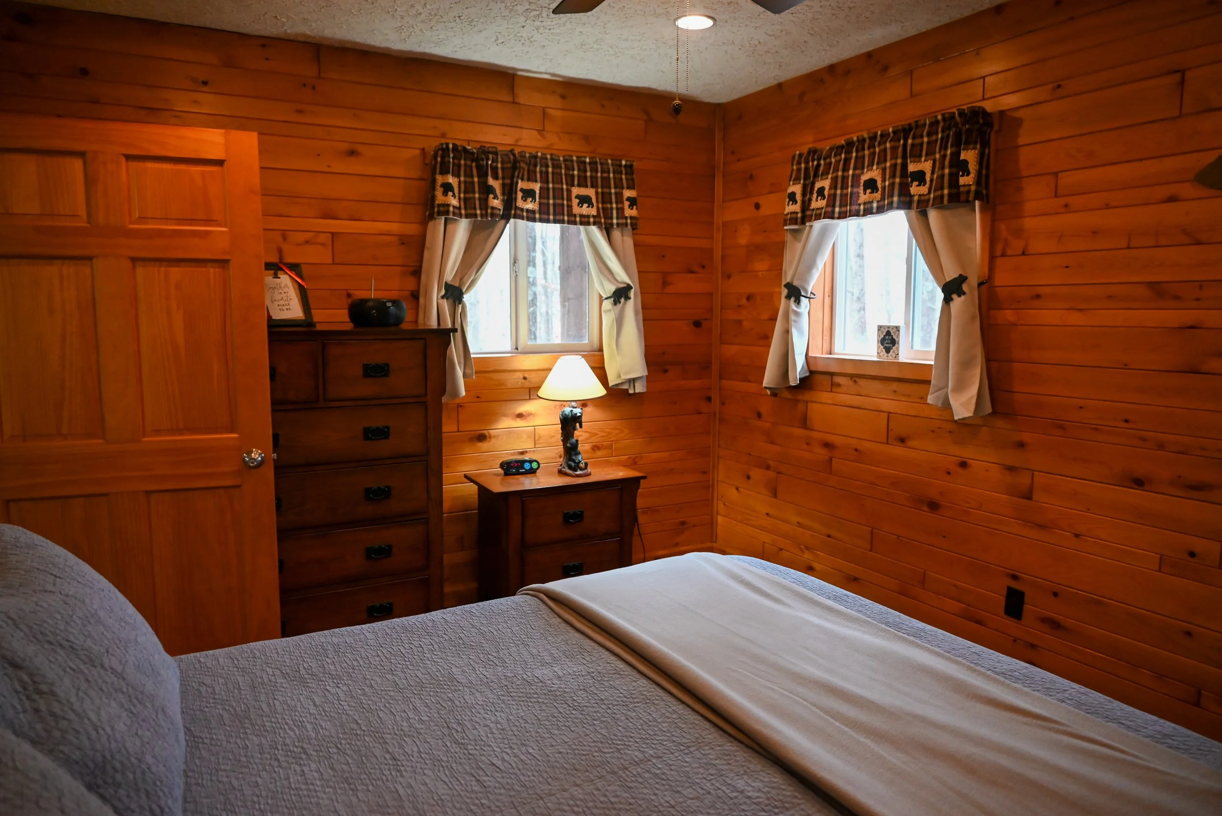 Warm, wood‑paneled bedroom at Beary Cozy Cabin offering a soft, romantic glow—perfect for couples seeking a peaceful Hocking Hills retreat.