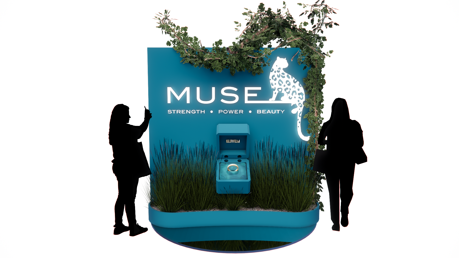 Exhibition booth with blue background displaying the word 'MUSE' and symbols for strength, power, and beauty. Silhouettes of two women observing, one taking a photo and the other looking at the display. The booth is decorated with greenery; a small blue jewelry box with an engagement ring is placed at the center.