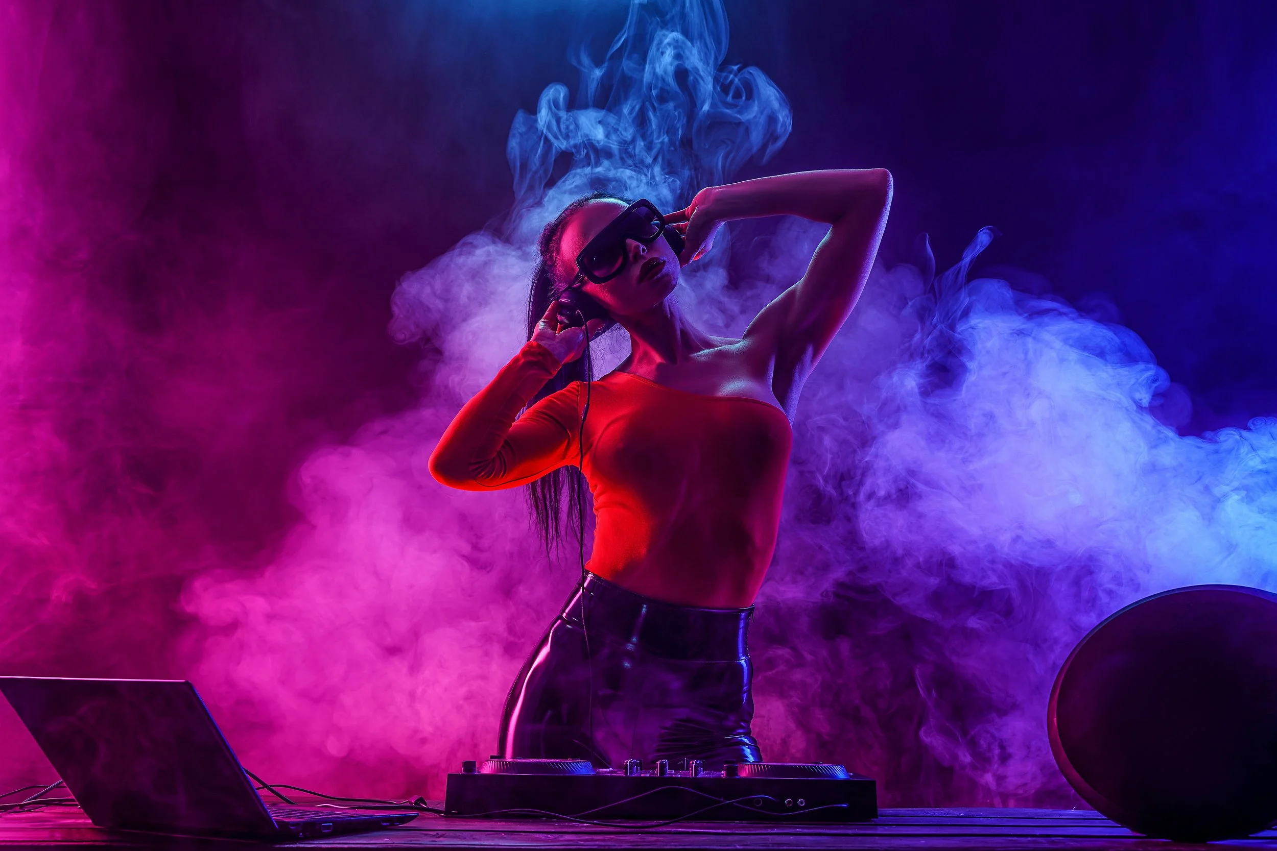 Female DJ performing at an event venue.