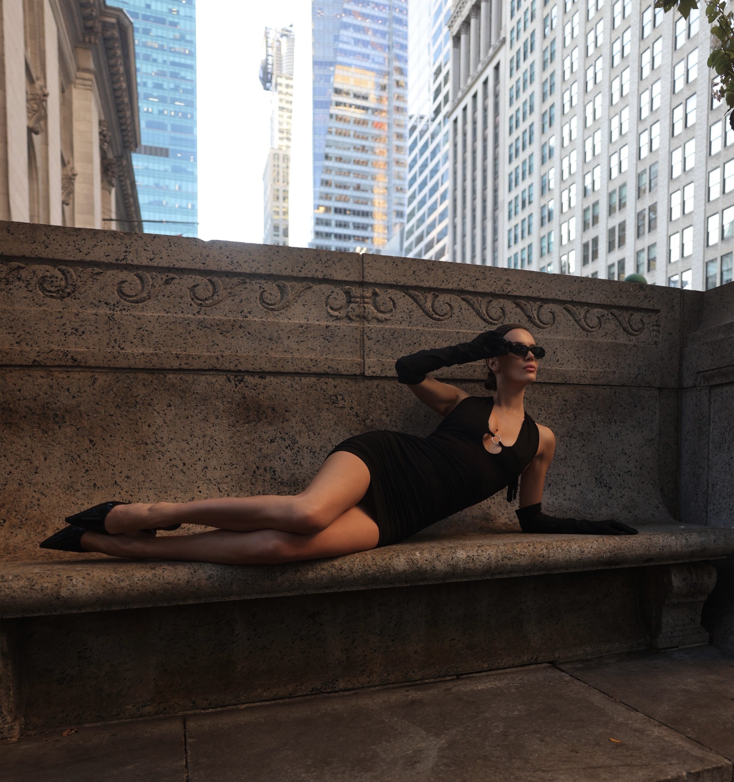 Model lying on bench overlooking New York City.