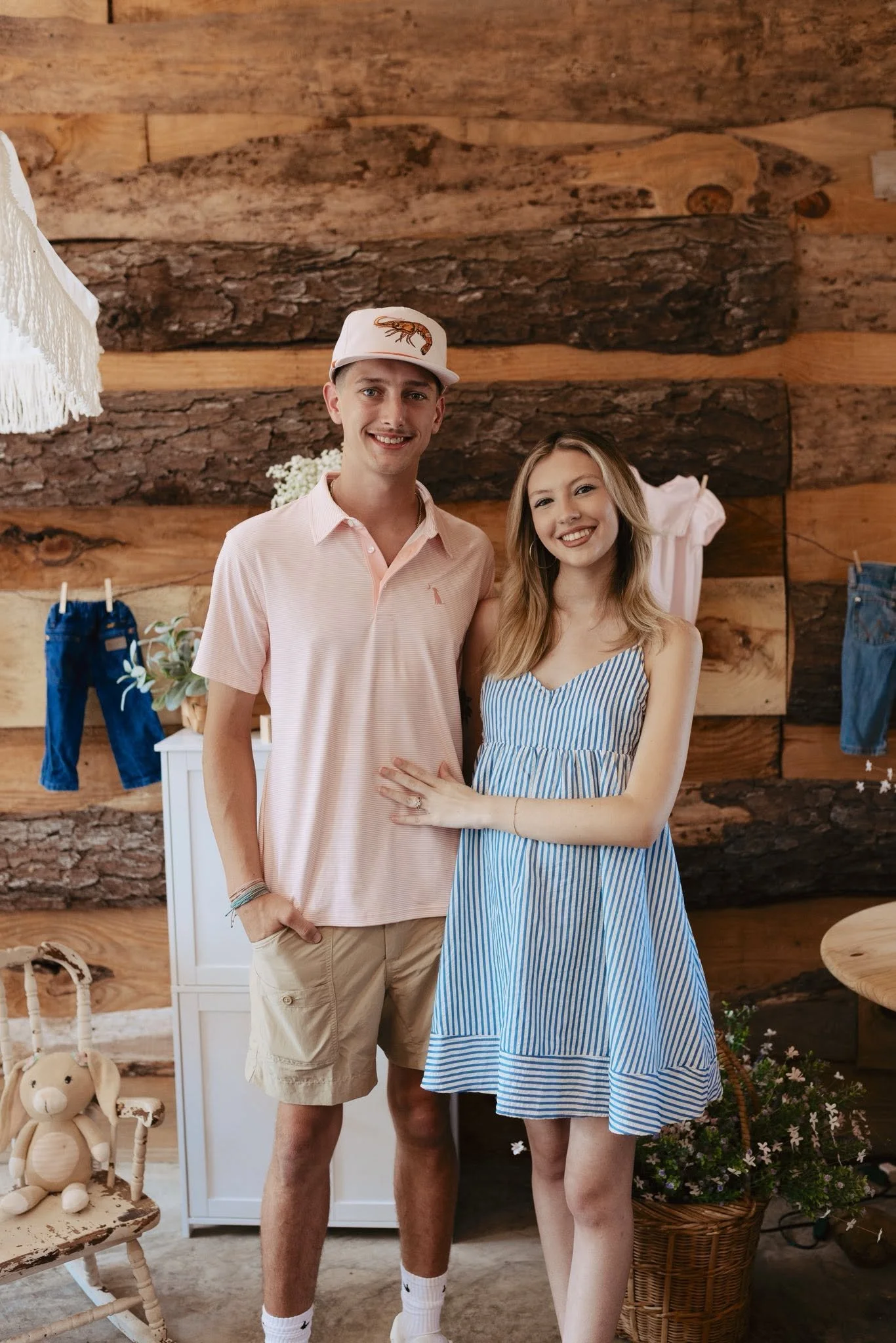 Smiling young couple posing together in a rustic wood-paneled room