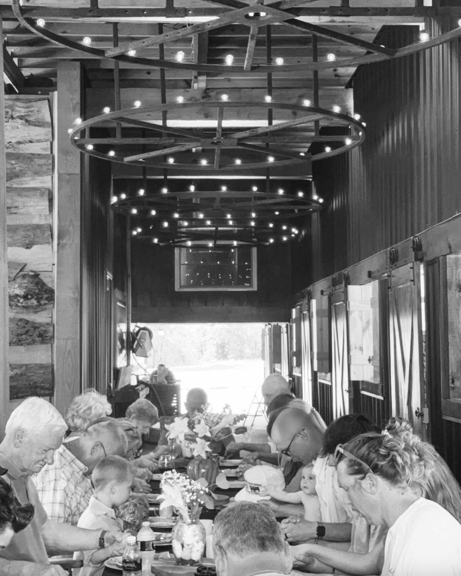 Family dining together at a rustic restaurant beneath circular string-light chandeliers