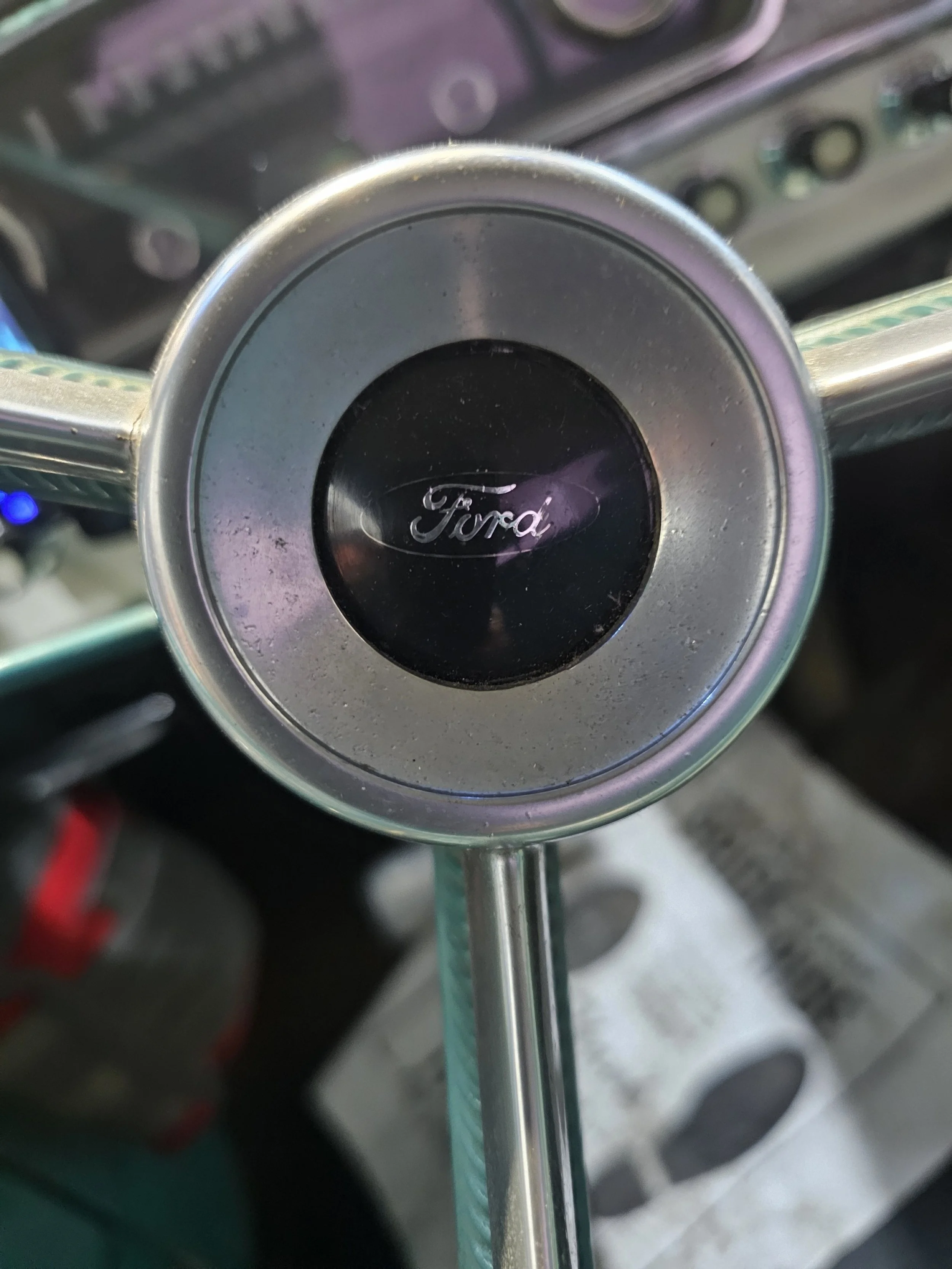 Close-up of a Ford steering wheel with the Ford logo in the center.