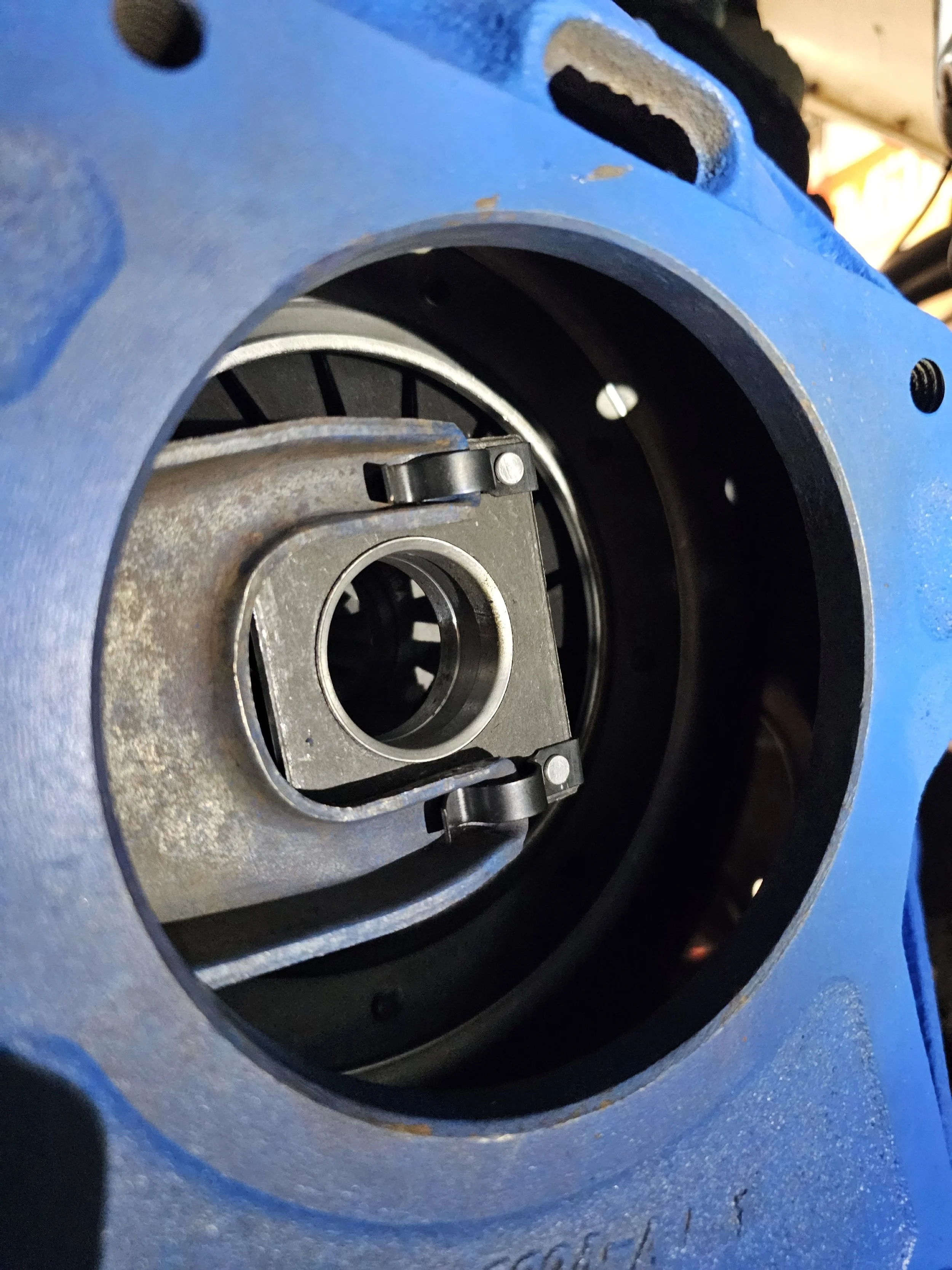 Close-up of a mechanical component inside a blue machine, showing a bearing and metal parts.
