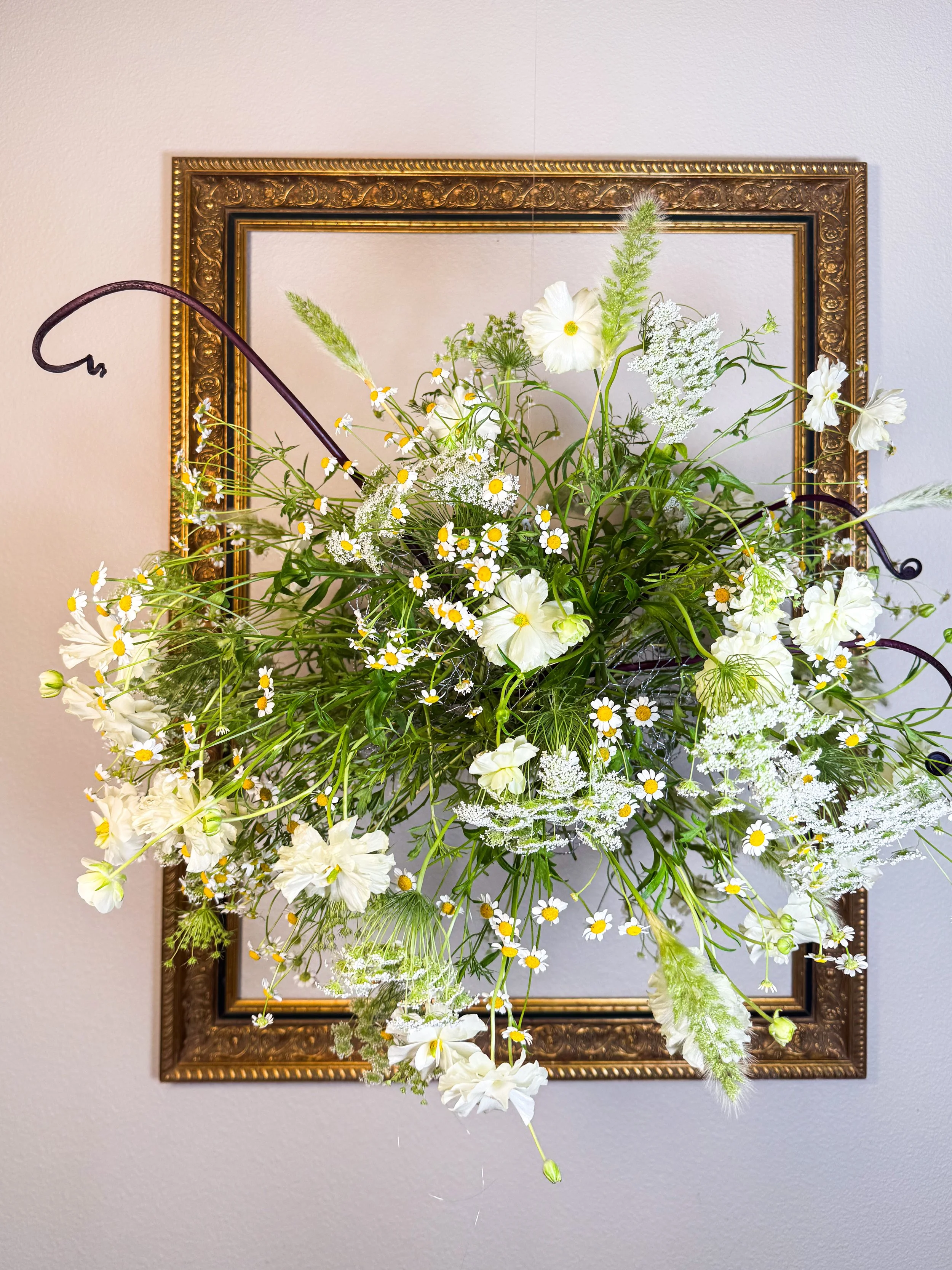sculptural floral installation with meadow floral branching structure, and soft white blooms in a studio setting
