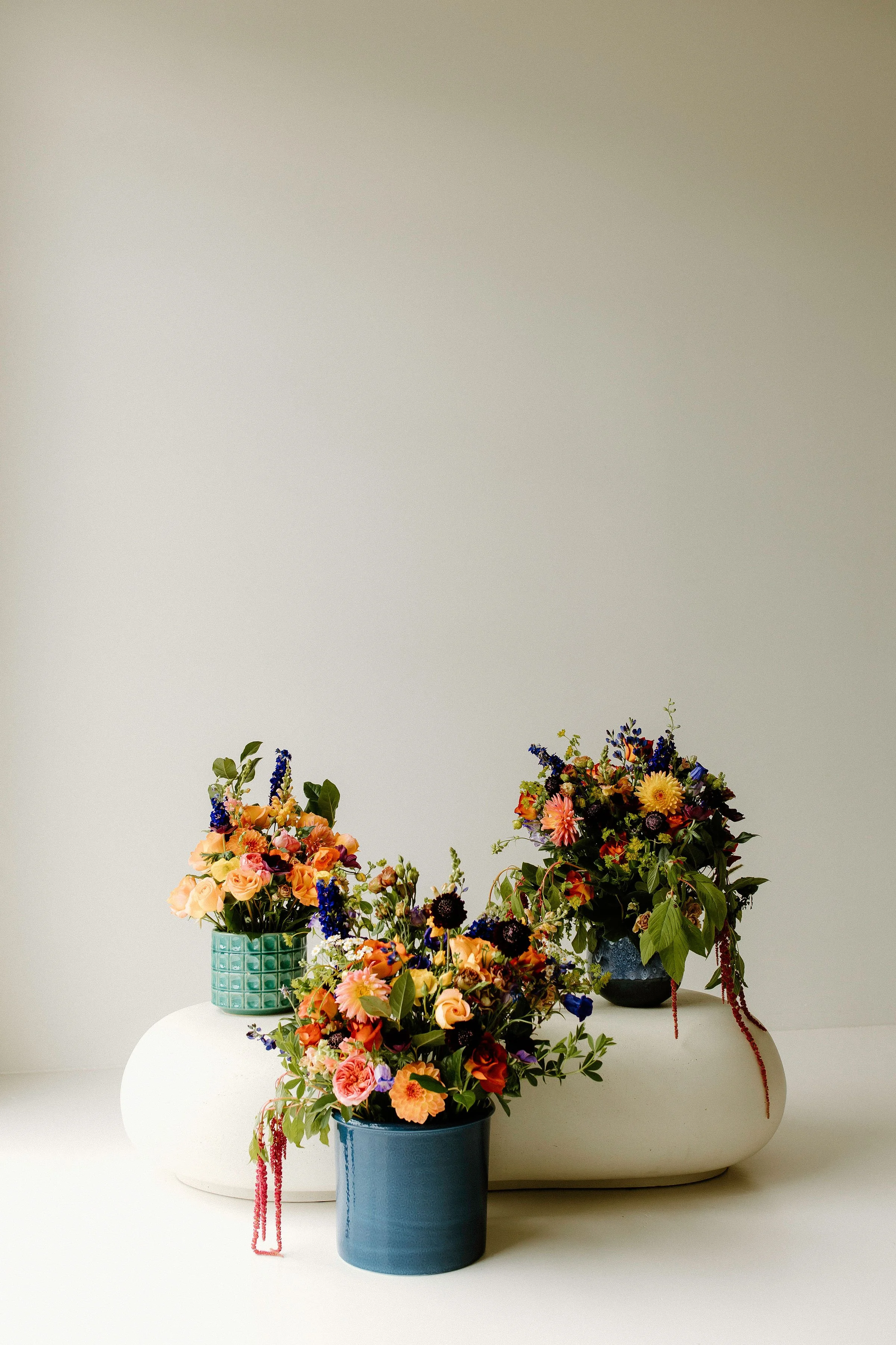 Collection of colorful floral arrangements in ceramic vases, styled for editorial and commercial use with a focus on vibrant hues, varied textures, and modern composition.