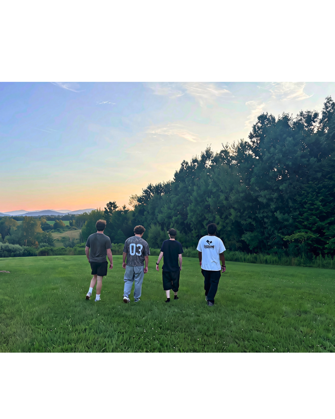Four Woodhaven Recovery residents walking together across the campus lawn at sunset.