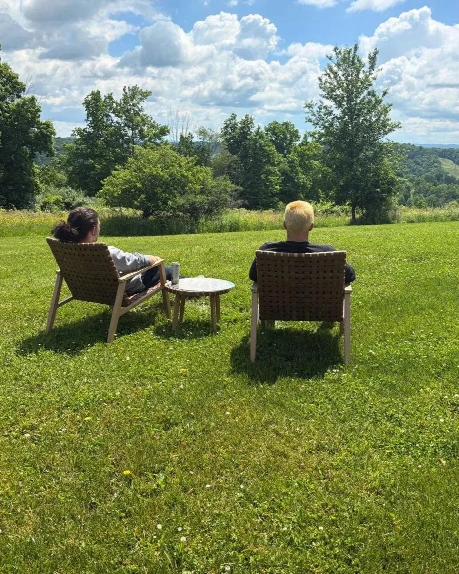 A Woodhaven Recovery mentor and young man sit outdoors together, reflecting connection, fellowship, and the shared experience of recovery.
