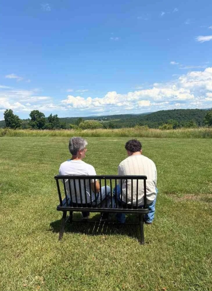 Woodhaven staff member and resident sitting on a bench overlooking the mountains.