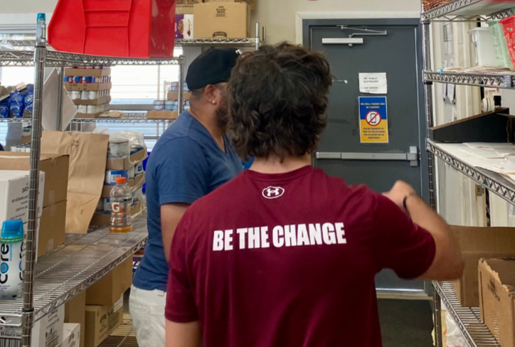Residents volunteer together at a community food pantry, sorting and stocking donations.