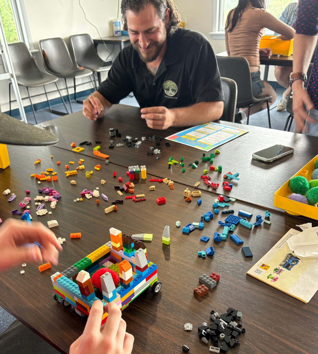 Woodhaven staff member participating in the LEGO vehicle challenge during Family Day