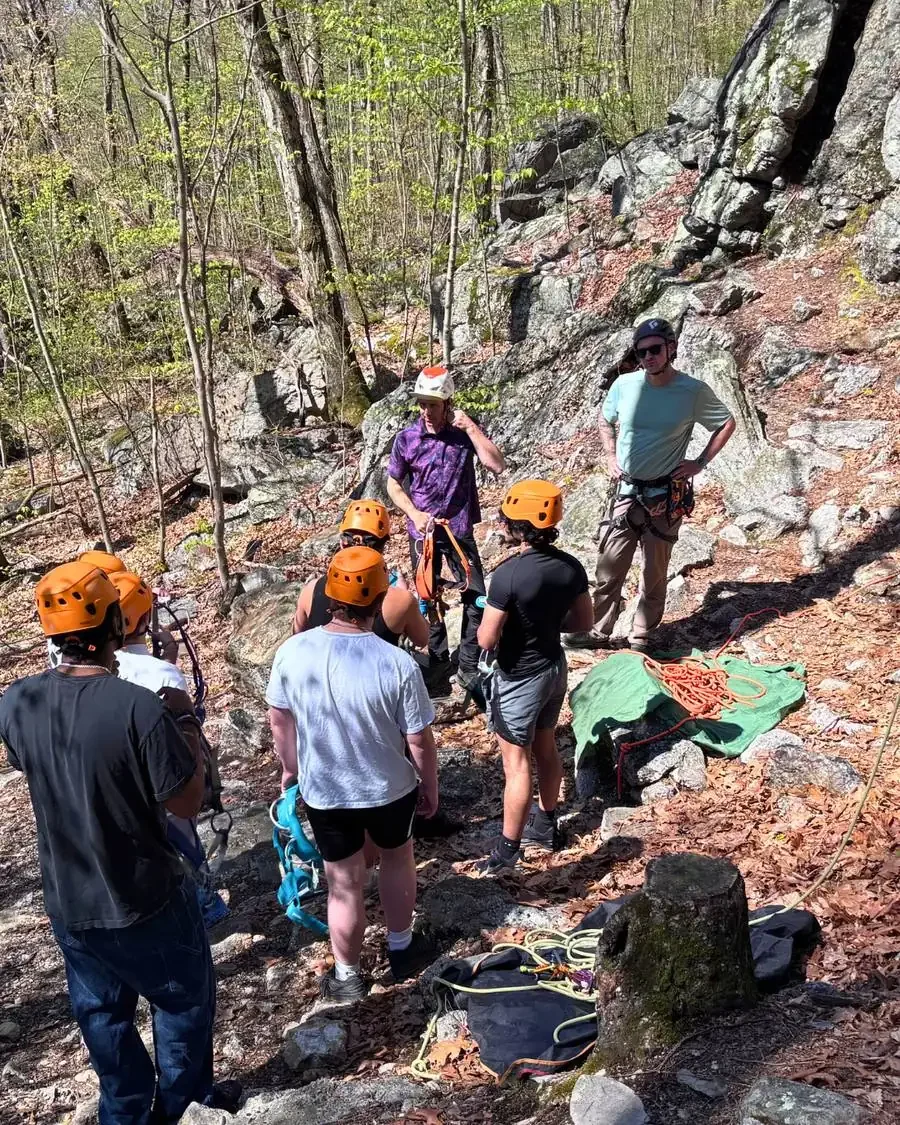 Teen boys rock climbing with staff support, representing recreation, trust, and comprehensive recovery support at Woodhaven Recovery.