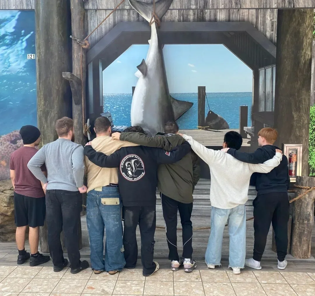 Teen boys standing together from behind during a recreational outing, representing friendship, shared experiences, and healthy connection in recovery at Woodhaven Recovery.