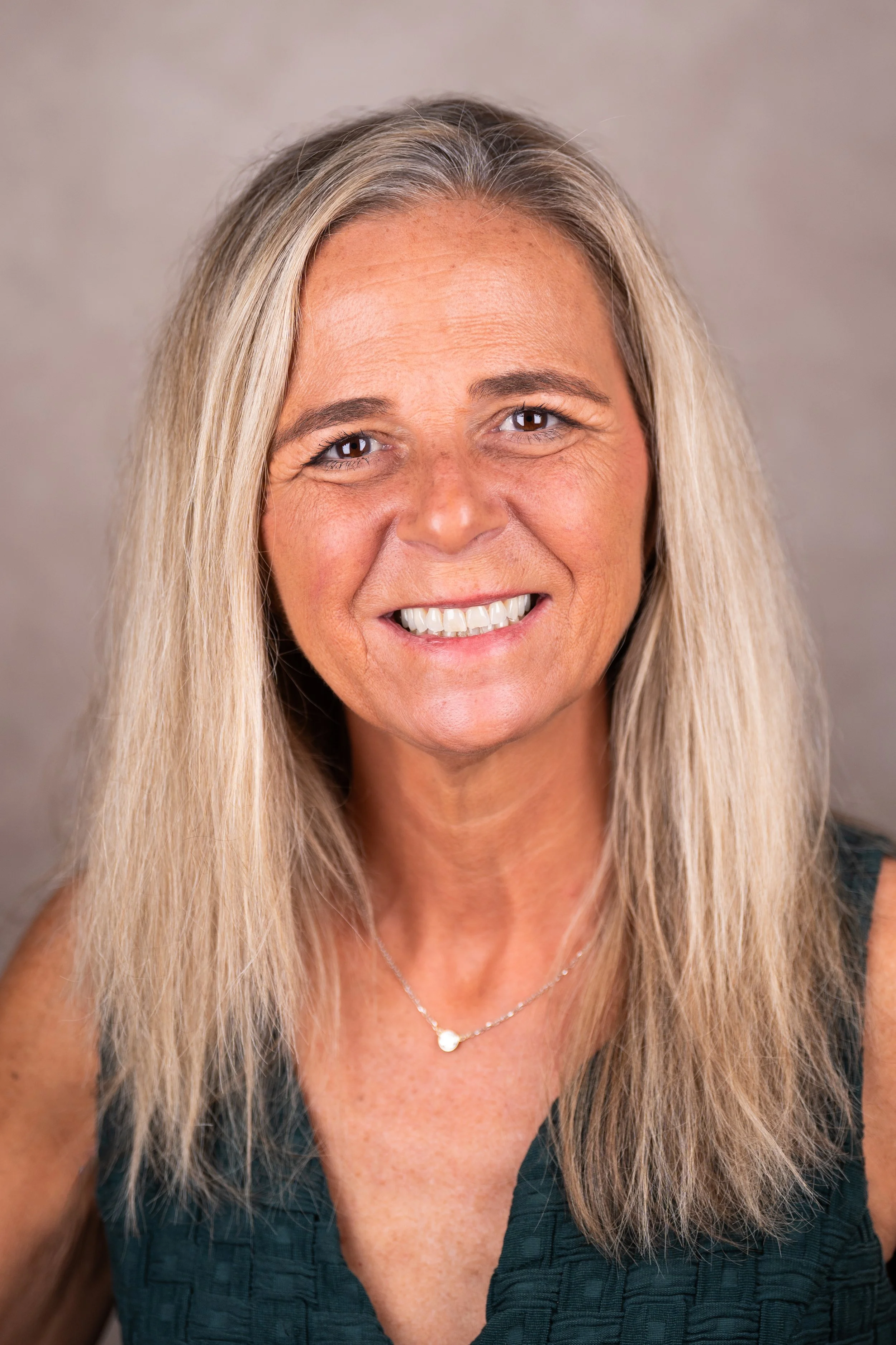 Headshot of Dr. Jill DeRosa, Co-Founder and Director of Education and Family Programs at Woodhaven Recovery, smiling in front of a neutral background.