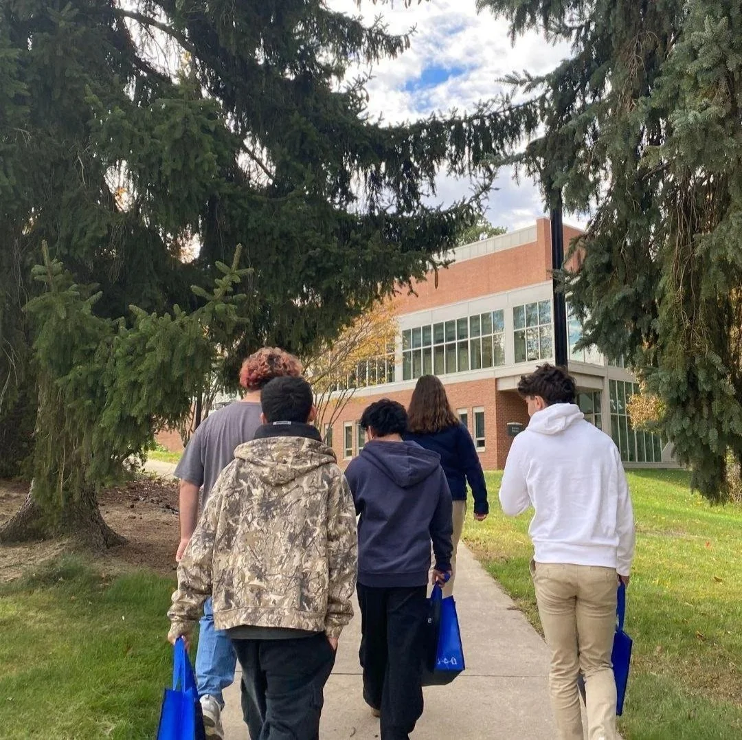 Woodhaven Prep students walk toward a college campus building during a campus visit focused on college planning, future goals, and recovery-supported education.