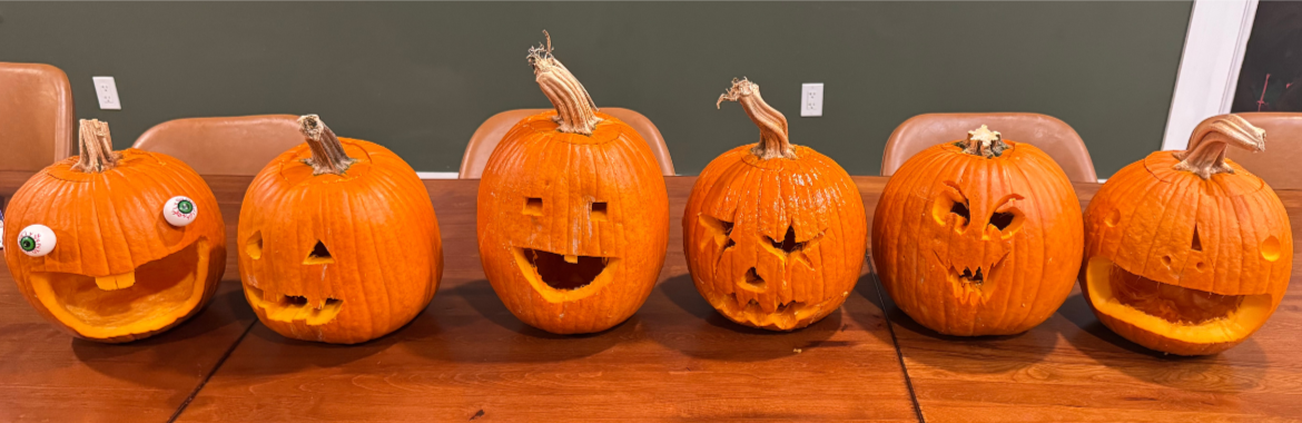 Carved pumpkins lined up on a table after a Halloween activity at Woodhaven.