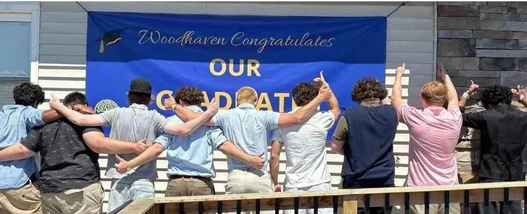 Woodhaven Prep students standing together in front of a graduation banner during the Class of 2026 celebration.