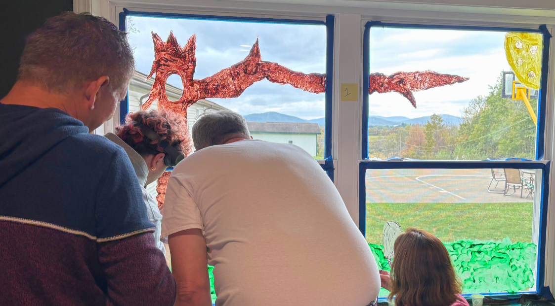 Families paint a fall window mural during a Woodhaven Family Day.