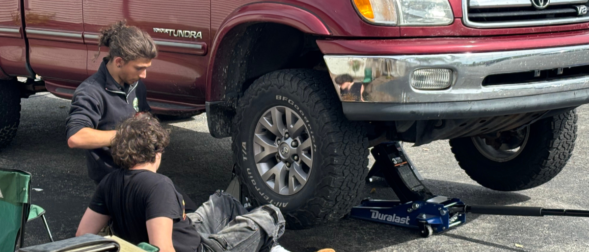 A staff member helps a resident to learn basic vehicle maintenance as a life skill.