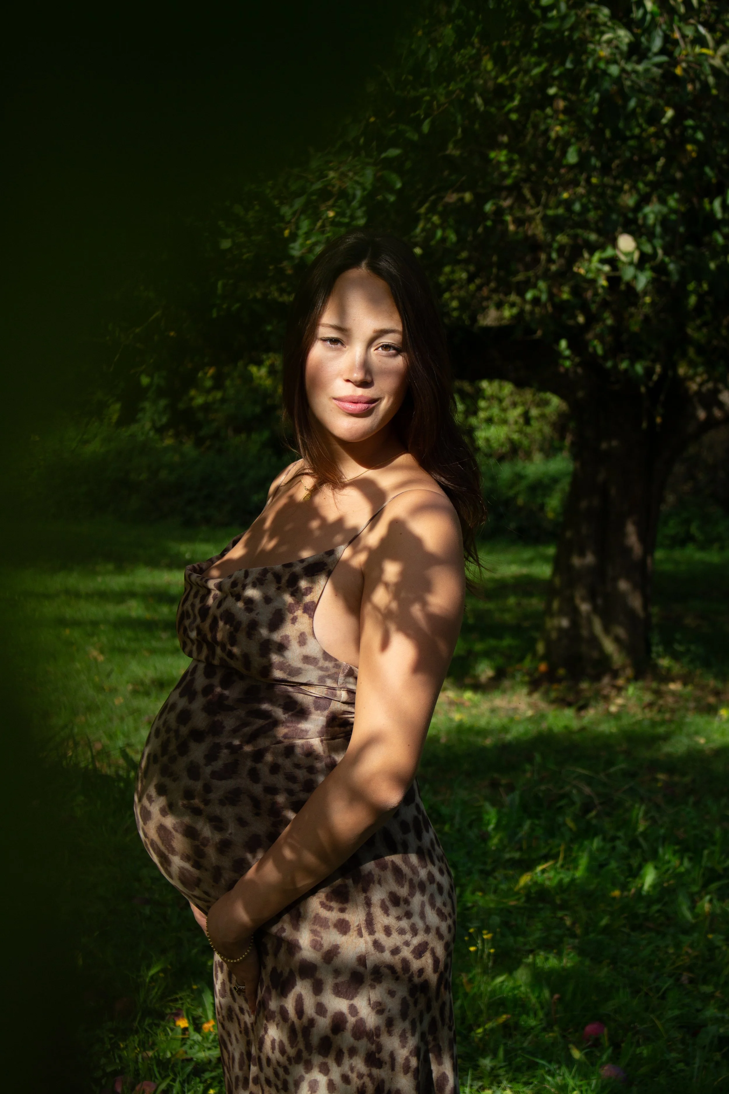 Empowerment-Foto einer Frau im Outdoor-Shooting mit Licht und Schatten und Apfelbäumen