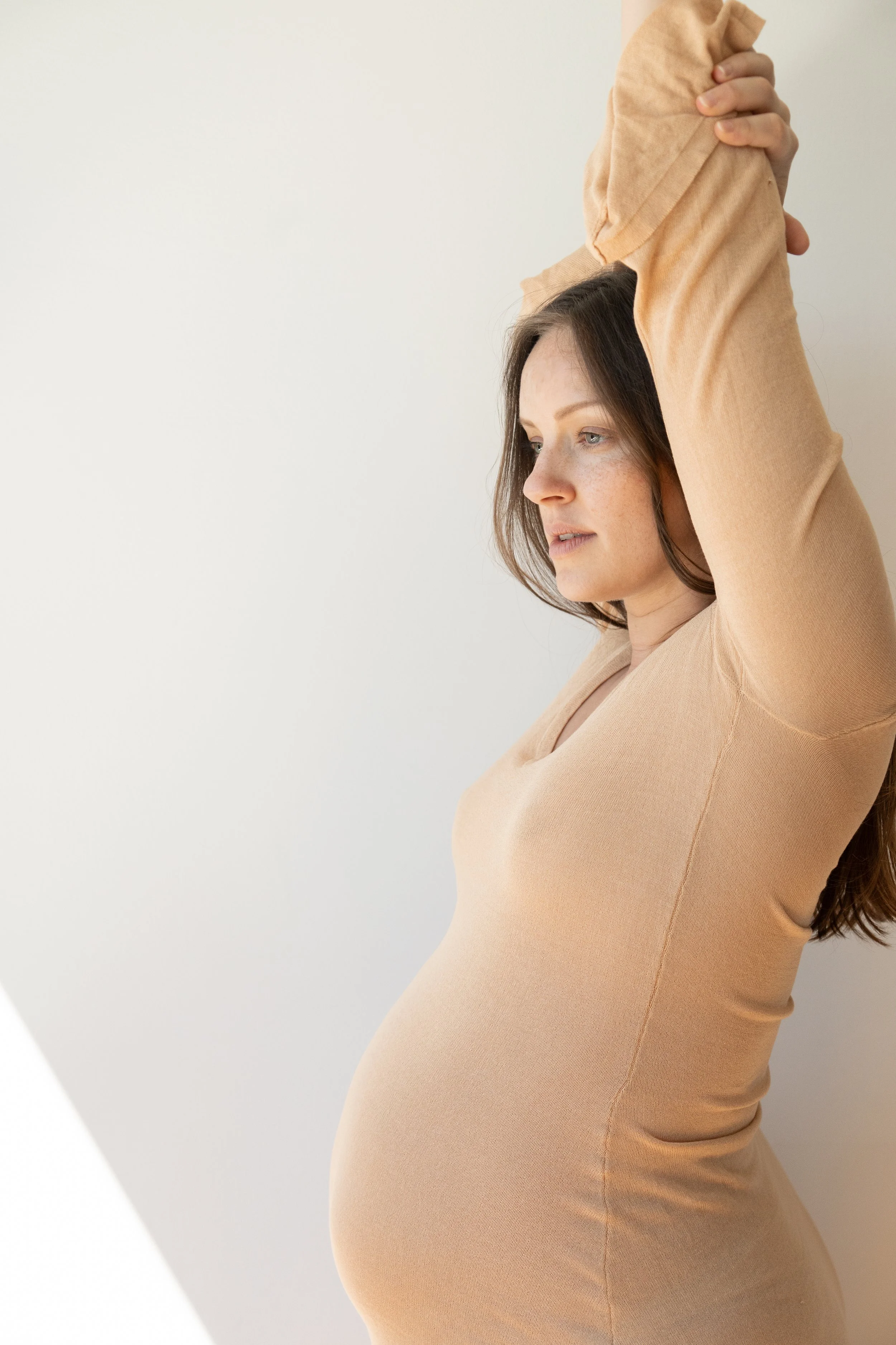 Porträt einer schwangeren Frau im Studio – ruhige Pose und weiches Licht