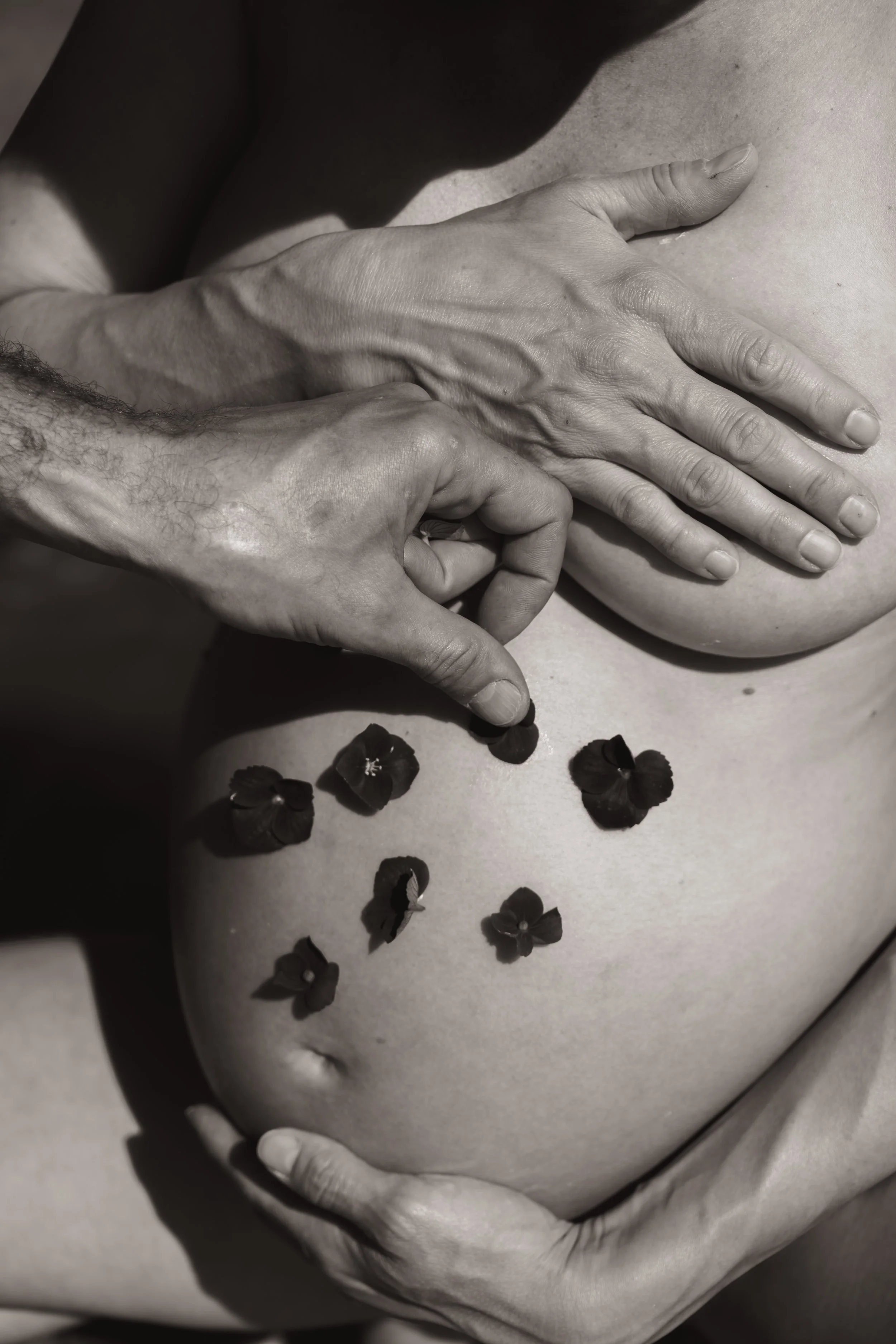Babybauch mit Blumen drauf schwarz weiss Fotografie 