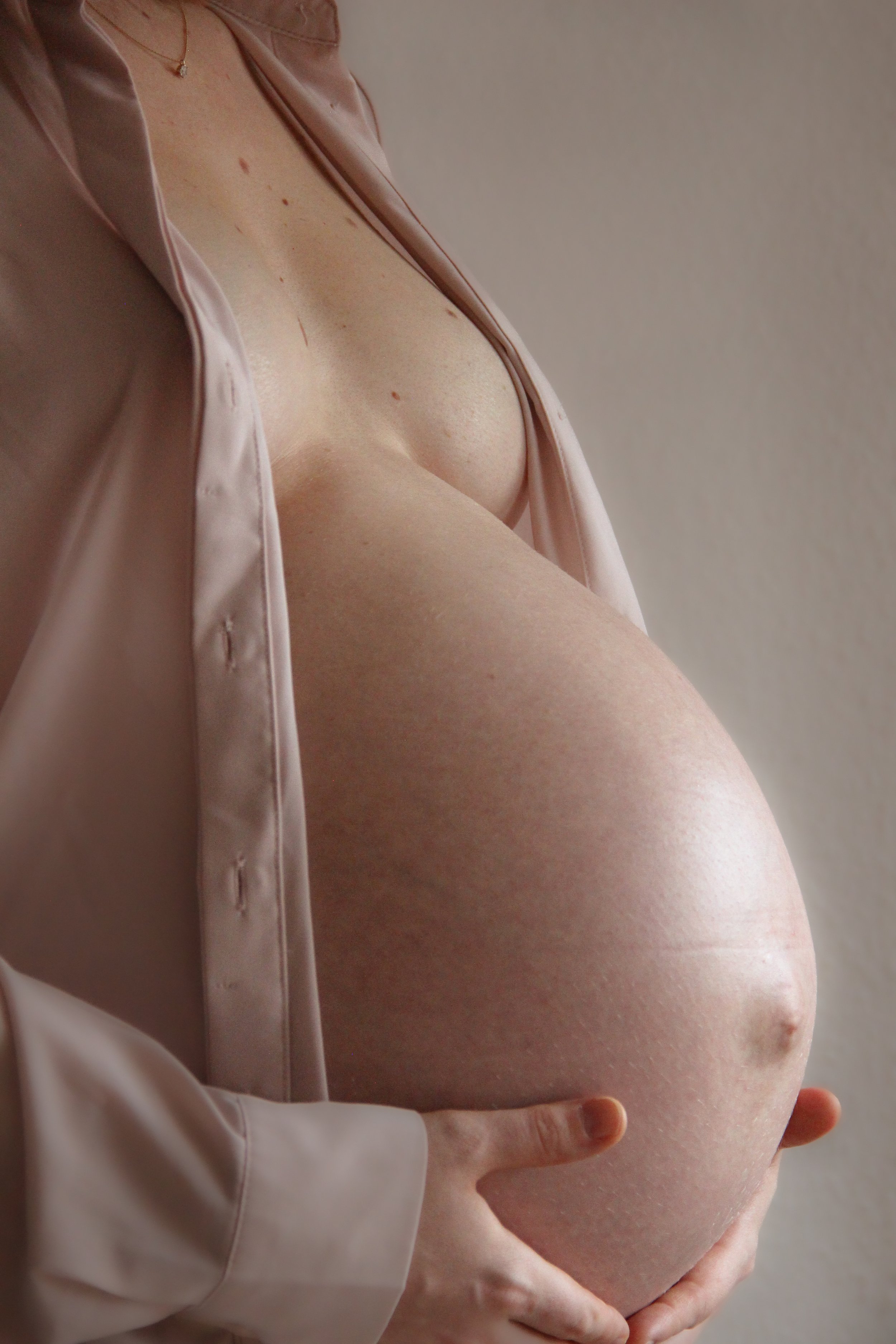 Porträt einer schwangeren Frau im Studio – ruhige Pose und weiches Licht