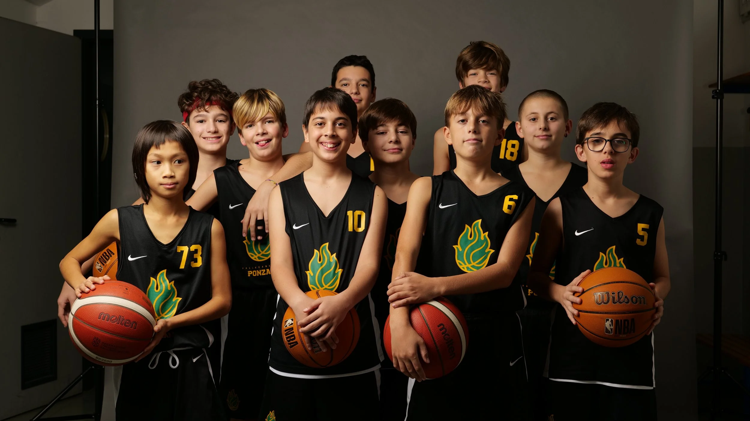 Gruppo di bambini dell'u13 maschile della pallacanestro ponzano in divisa da basket con palloni, posa in posa per una foto