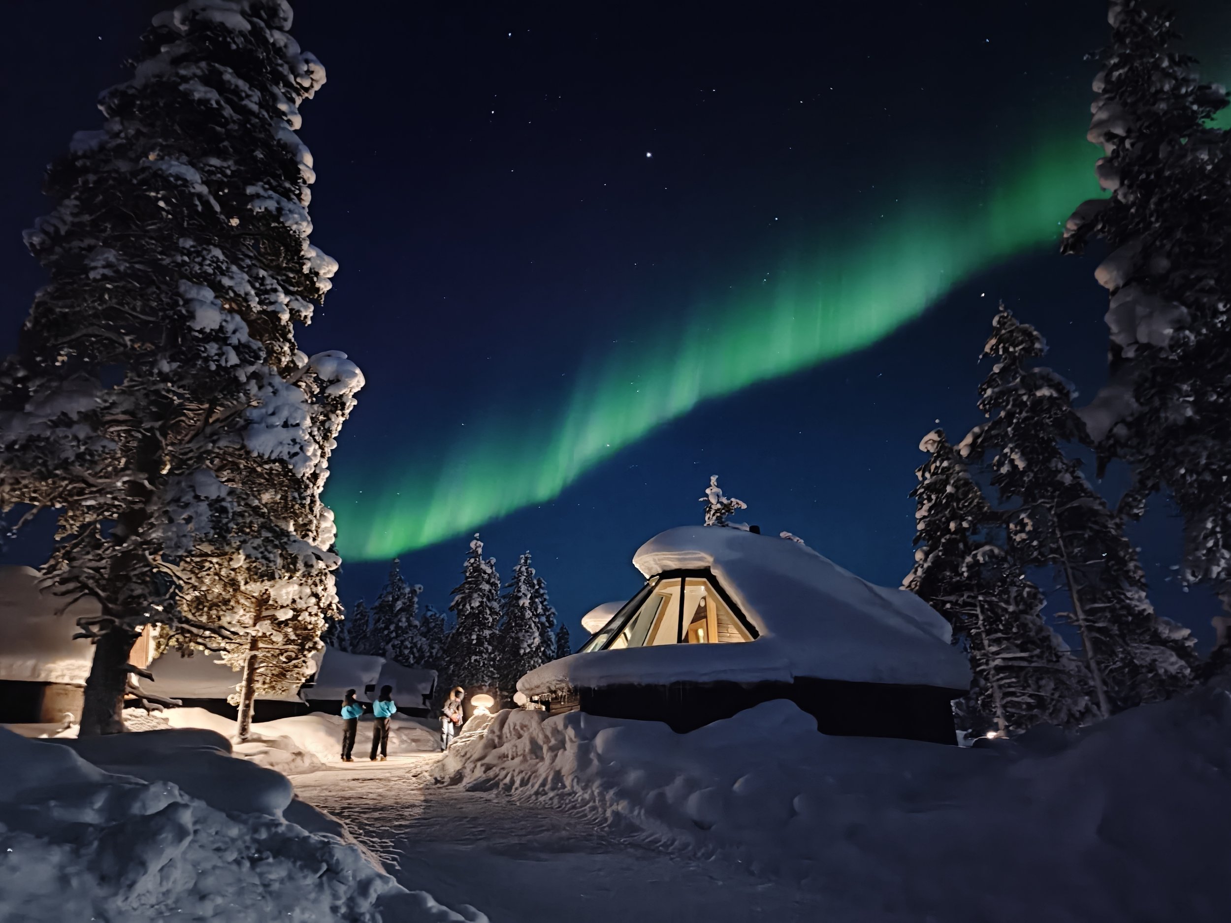 Green northern lights above igloo cottage
