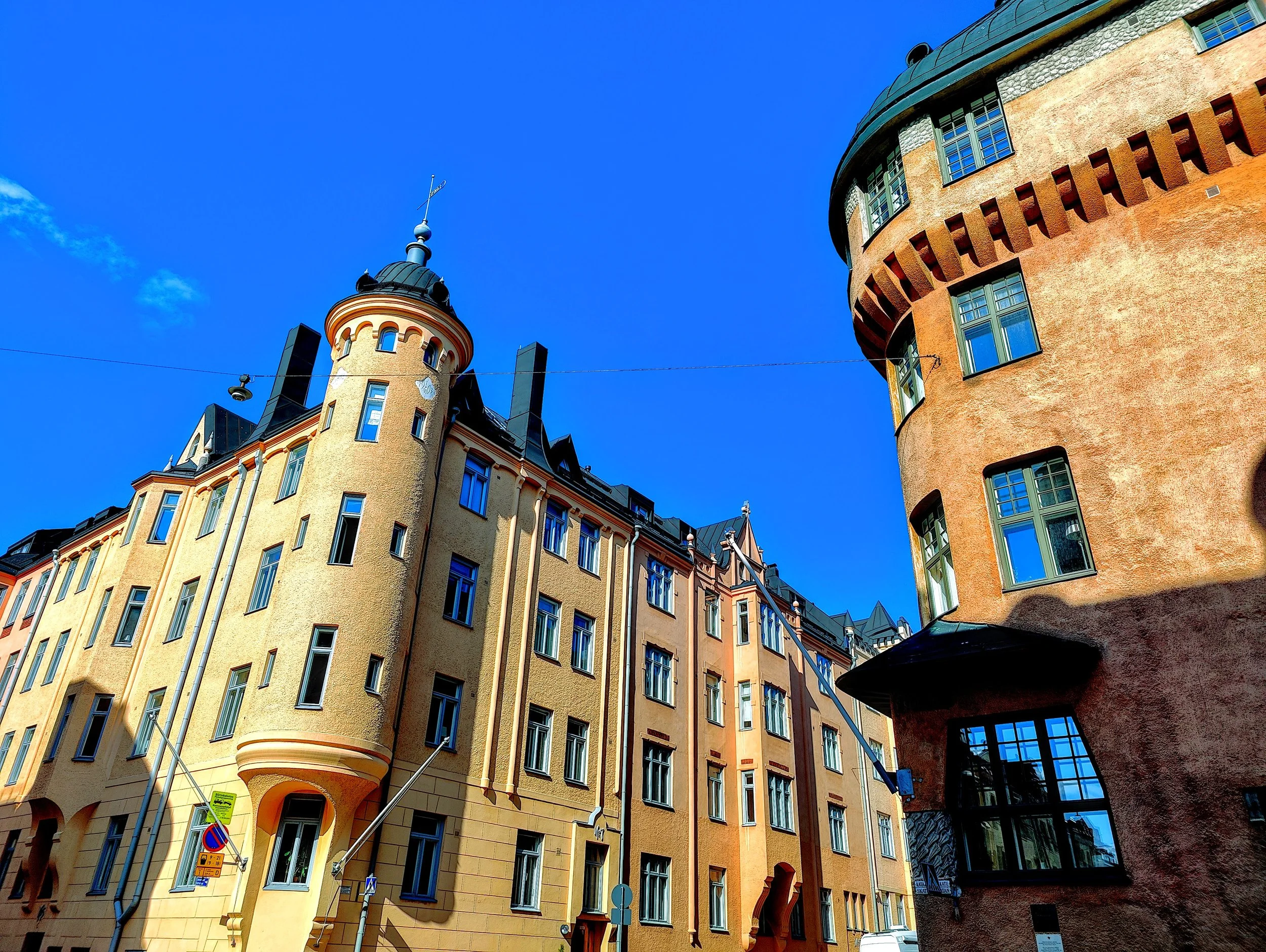 Colorful historic buildings with curved and angular facades under a clear blue sky.