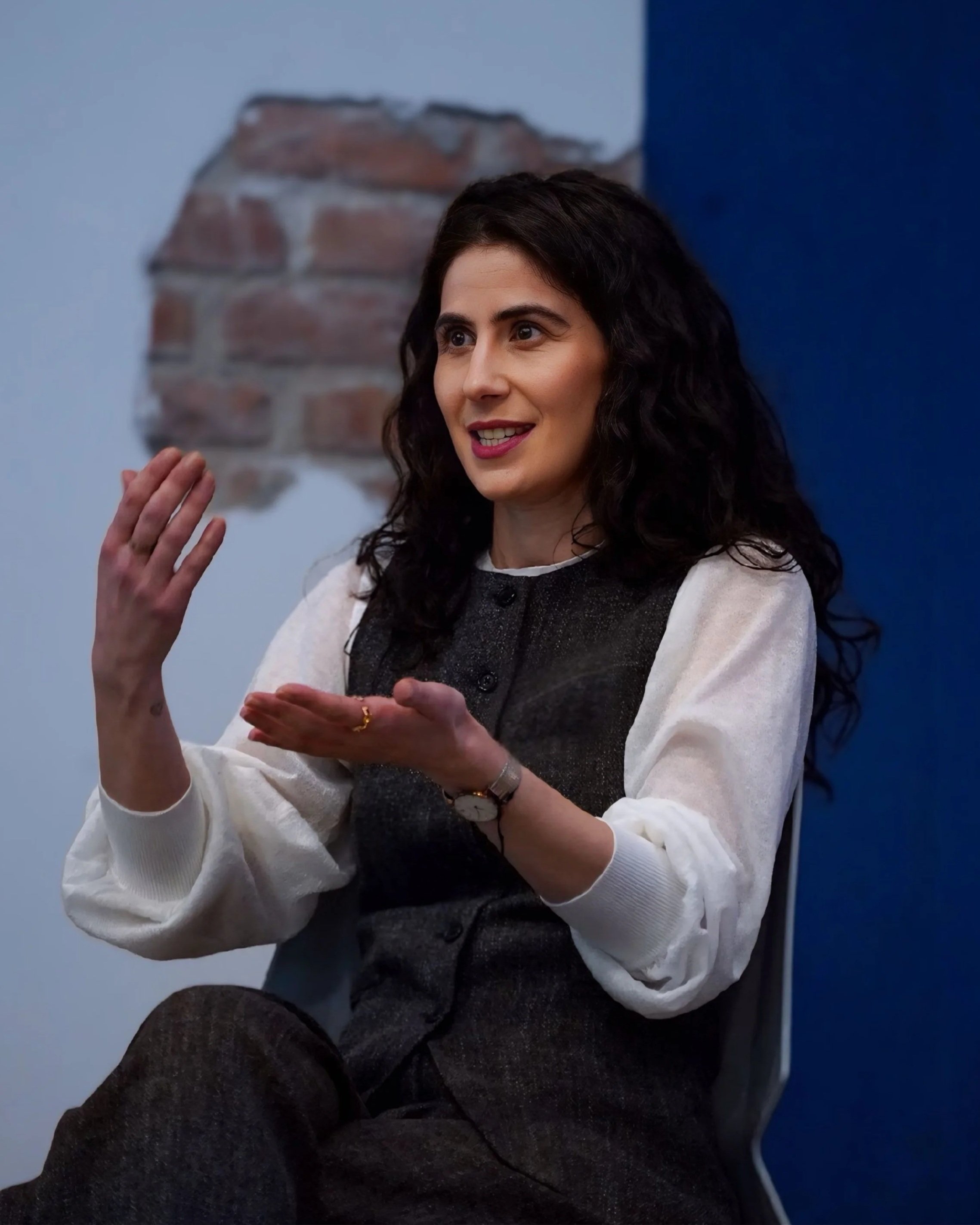 Hayriye Tekek gesturing while speaking in a workshop-style portrait for her LinkedIn strategy and training website.